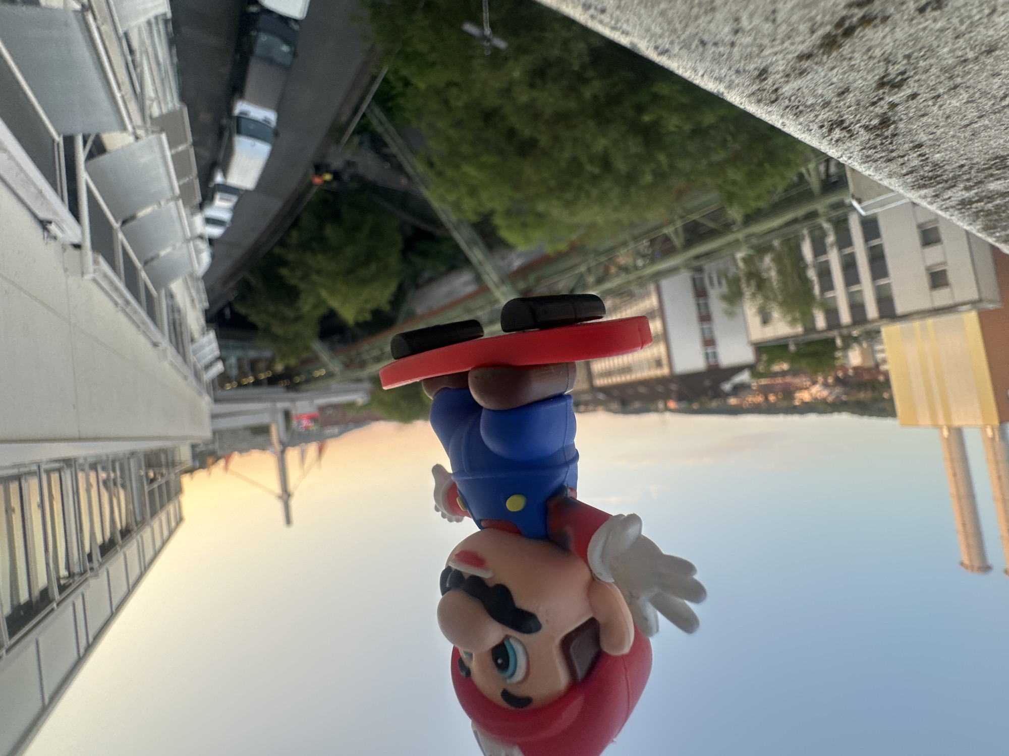 Mario figurine and city views across Wuppertal at golden hour