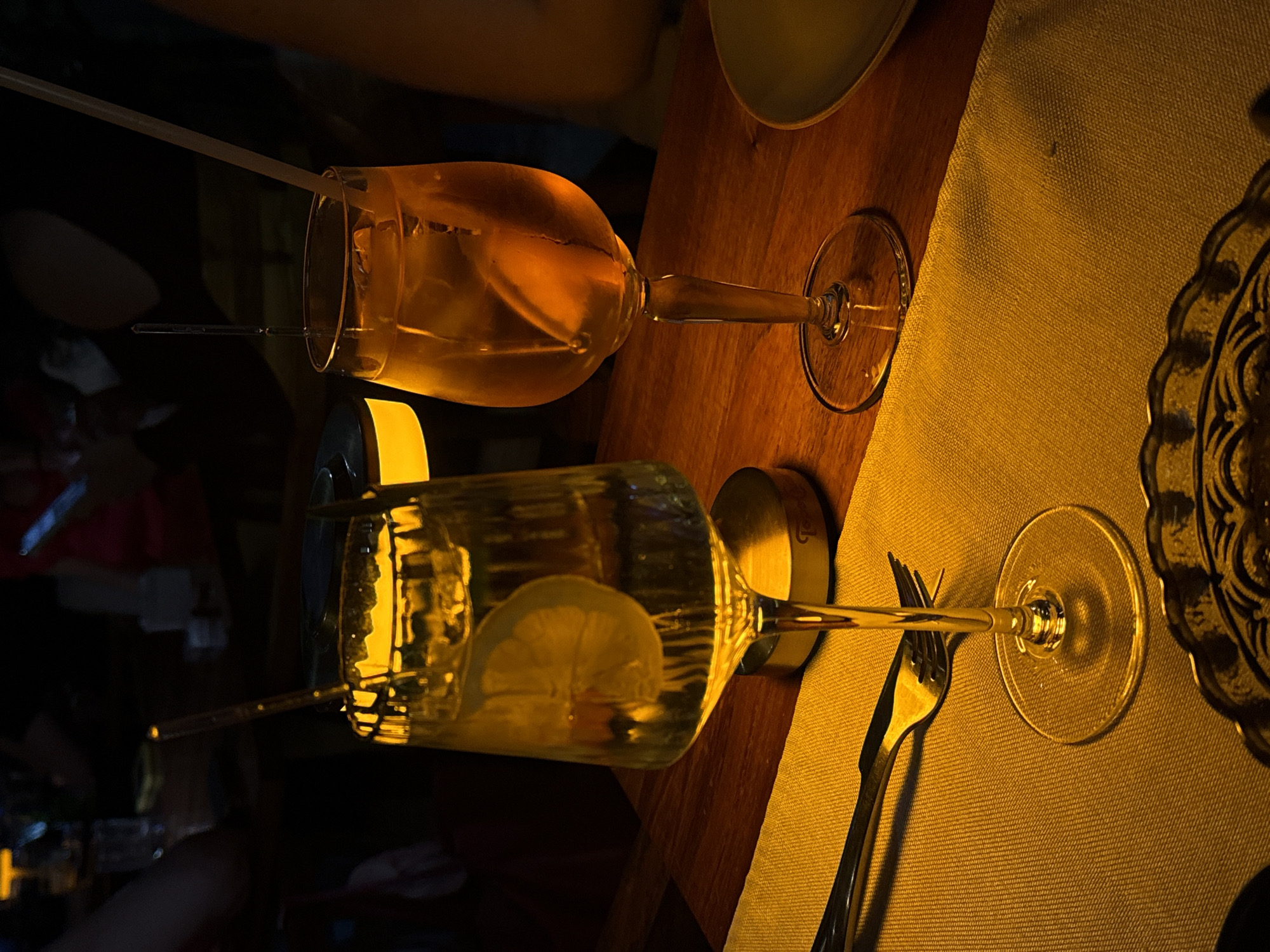 Stemmed glasses captured on wooden table in dimly lit establishment