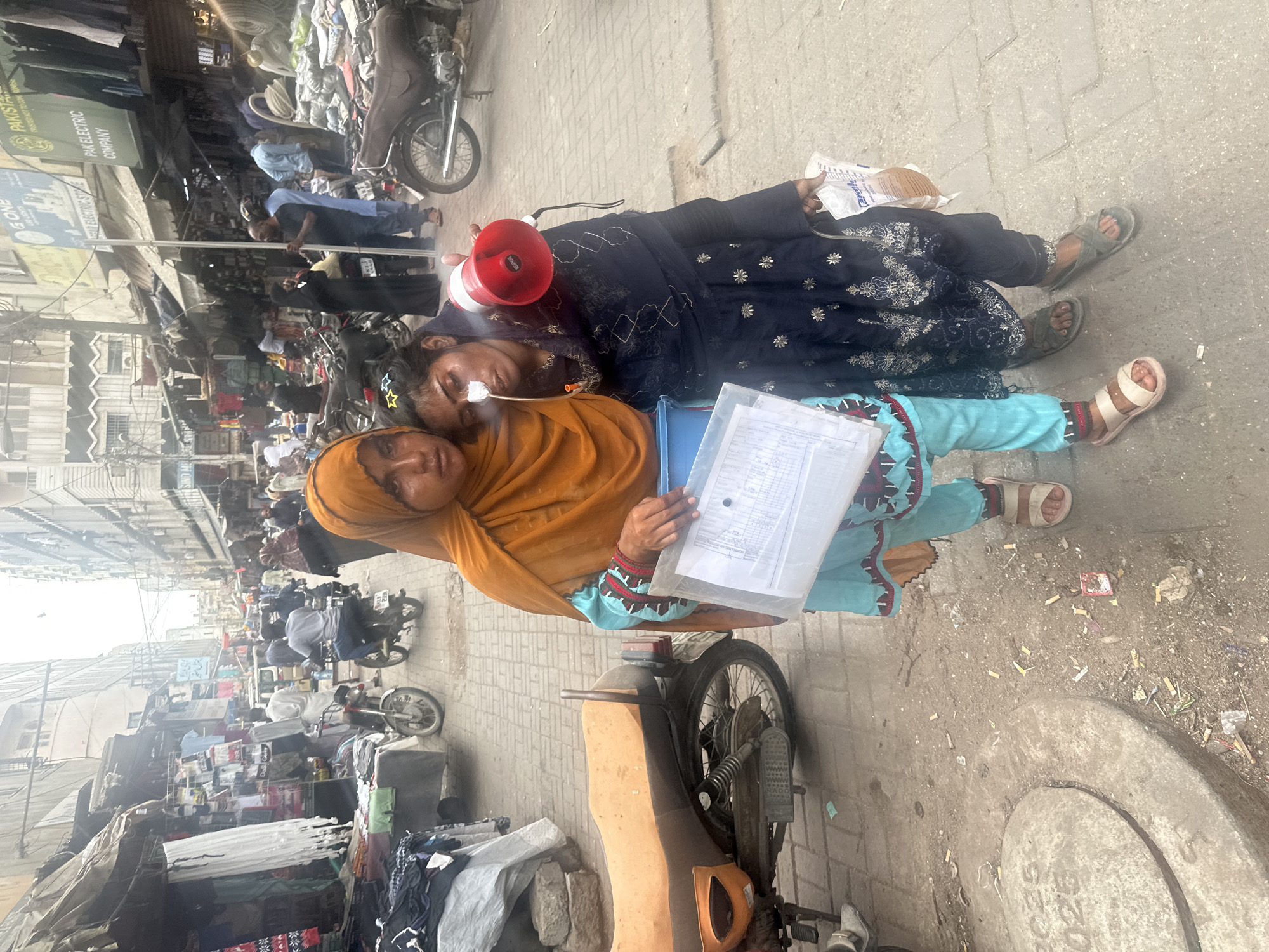 Two people in apparent distress on a Karachi street