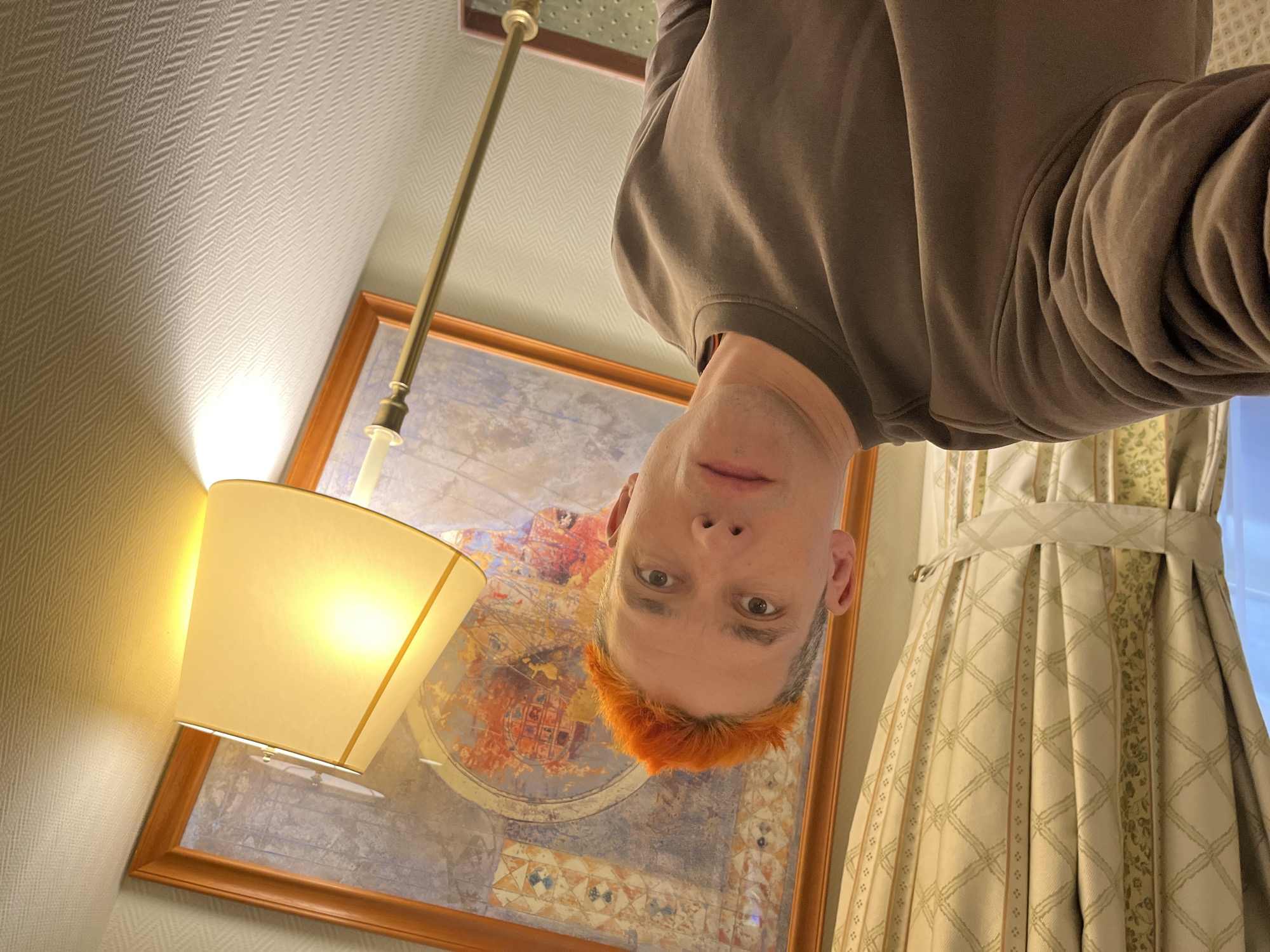 Orange-haired man photographed indoors in Moscow residential setting