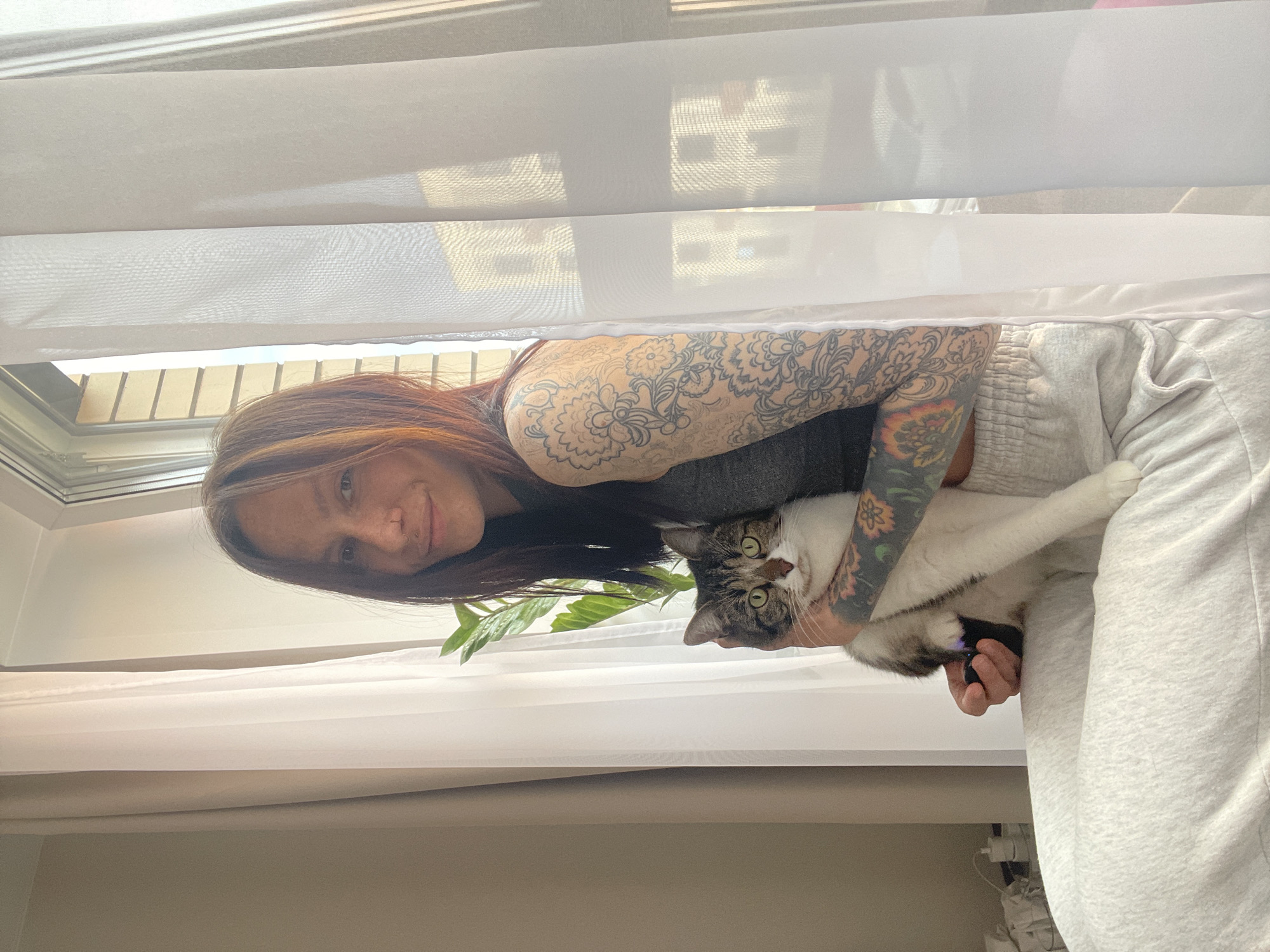 Tattooed woman photographed with tabby cat in Izhevsk home