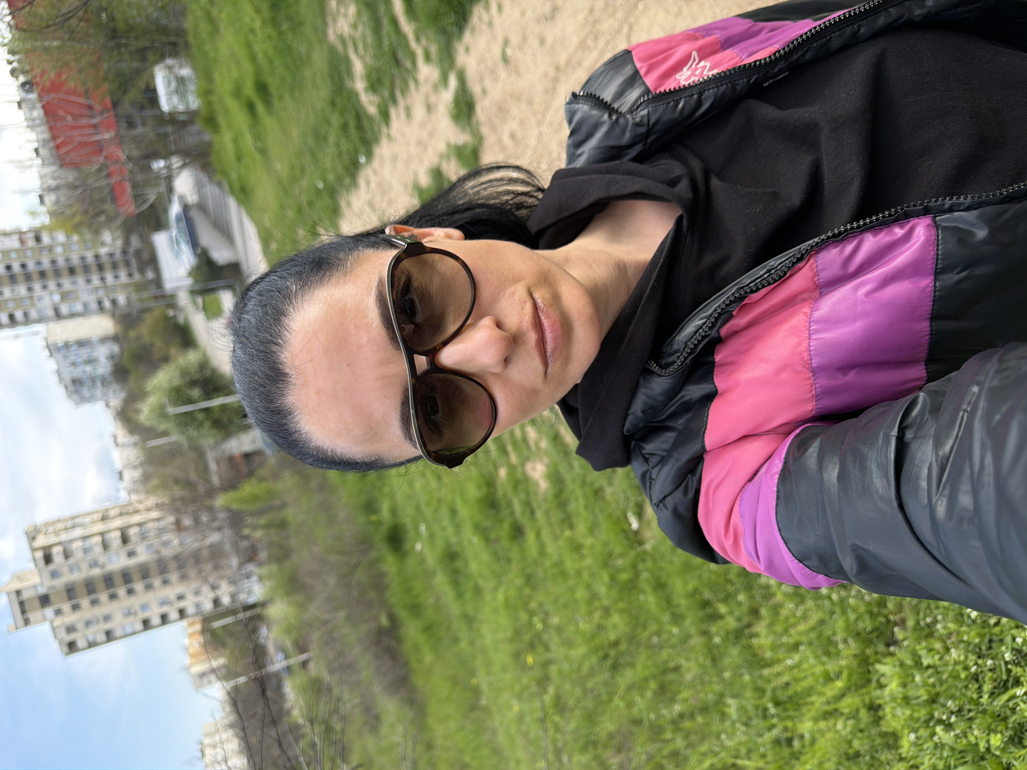 Woman takes selfies on Pleven street wearing colorful jacket