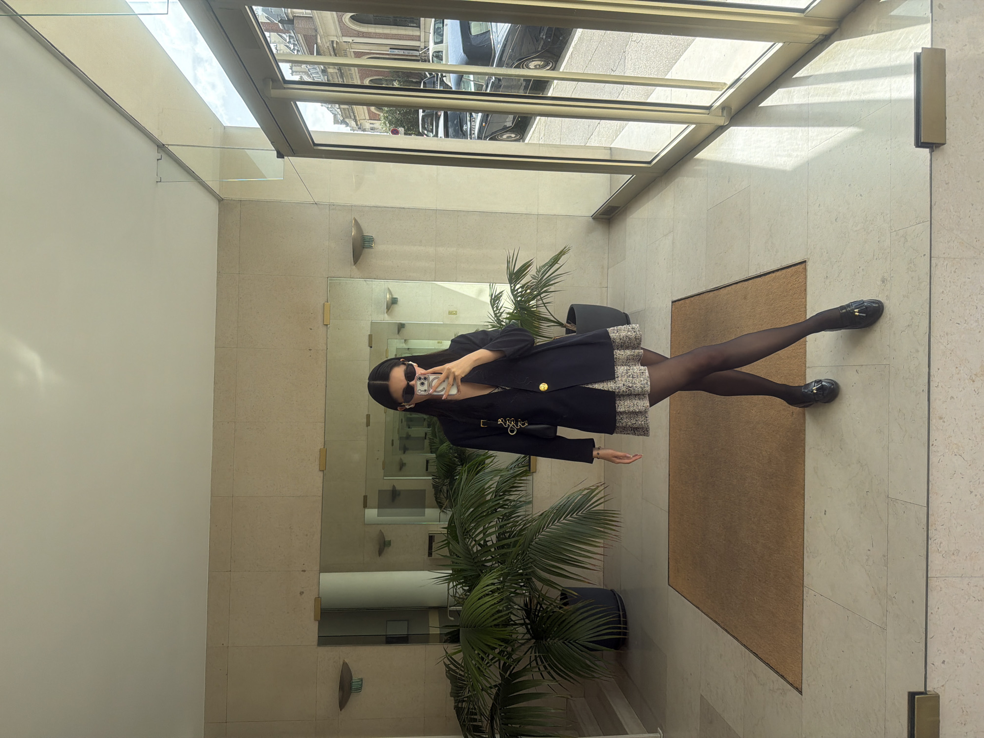 Woman takes selfie in stone building in Paris