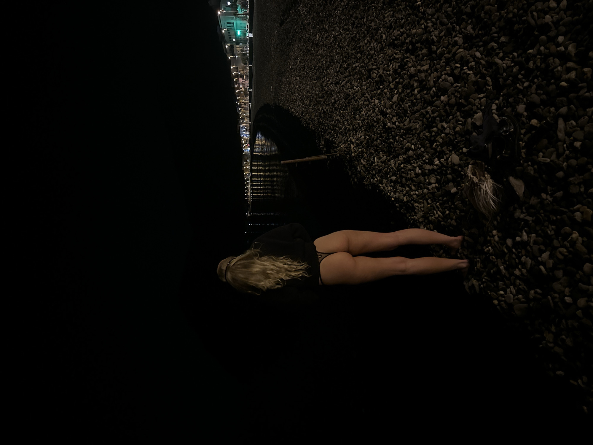 Person photographed resting by water at night in Lipari