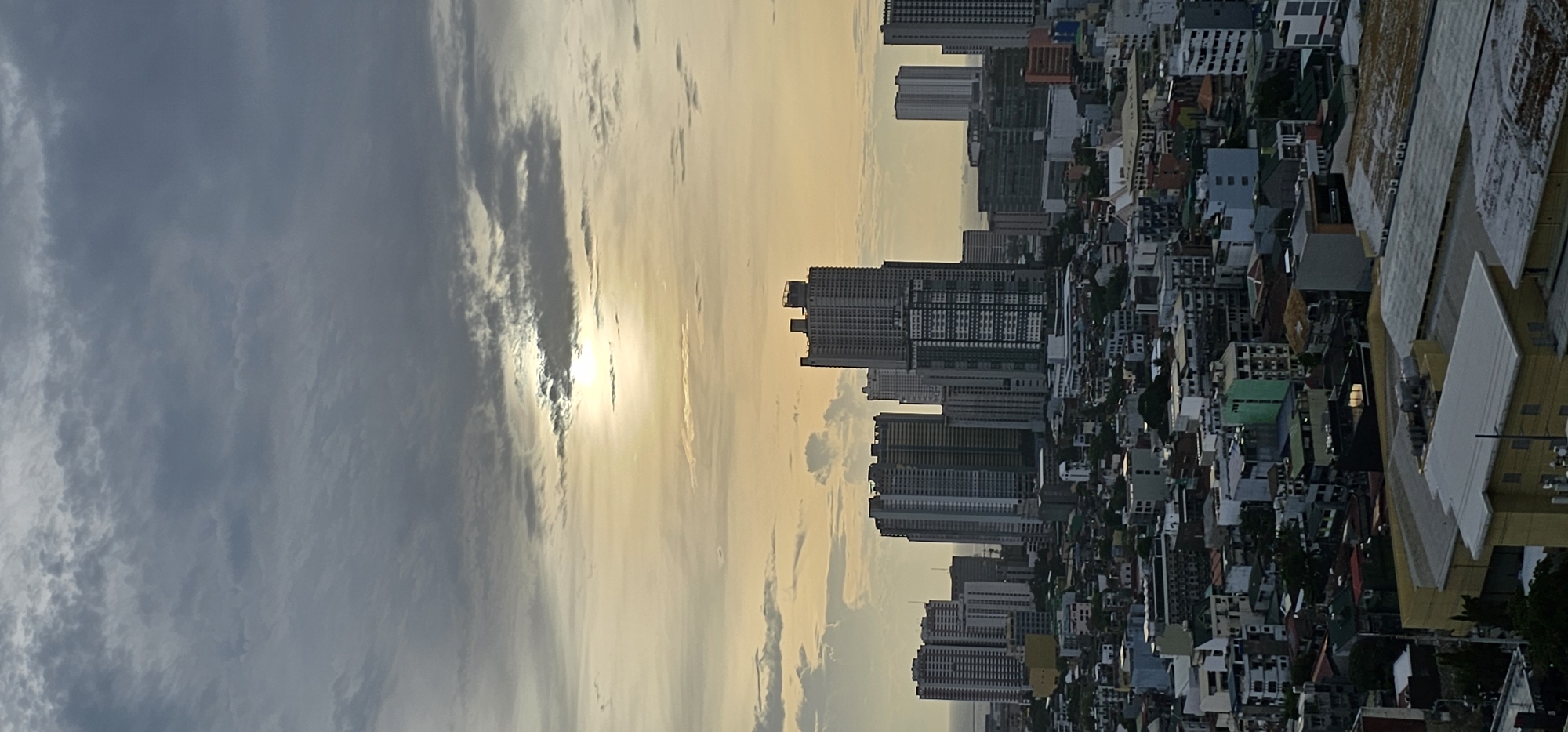 Makati skyline glows at dusk as a plane passes overhead