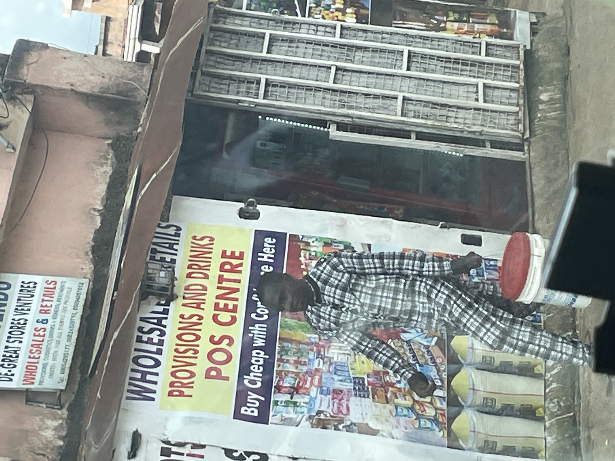 Midday street life and storefronts across Jos, Nigeria