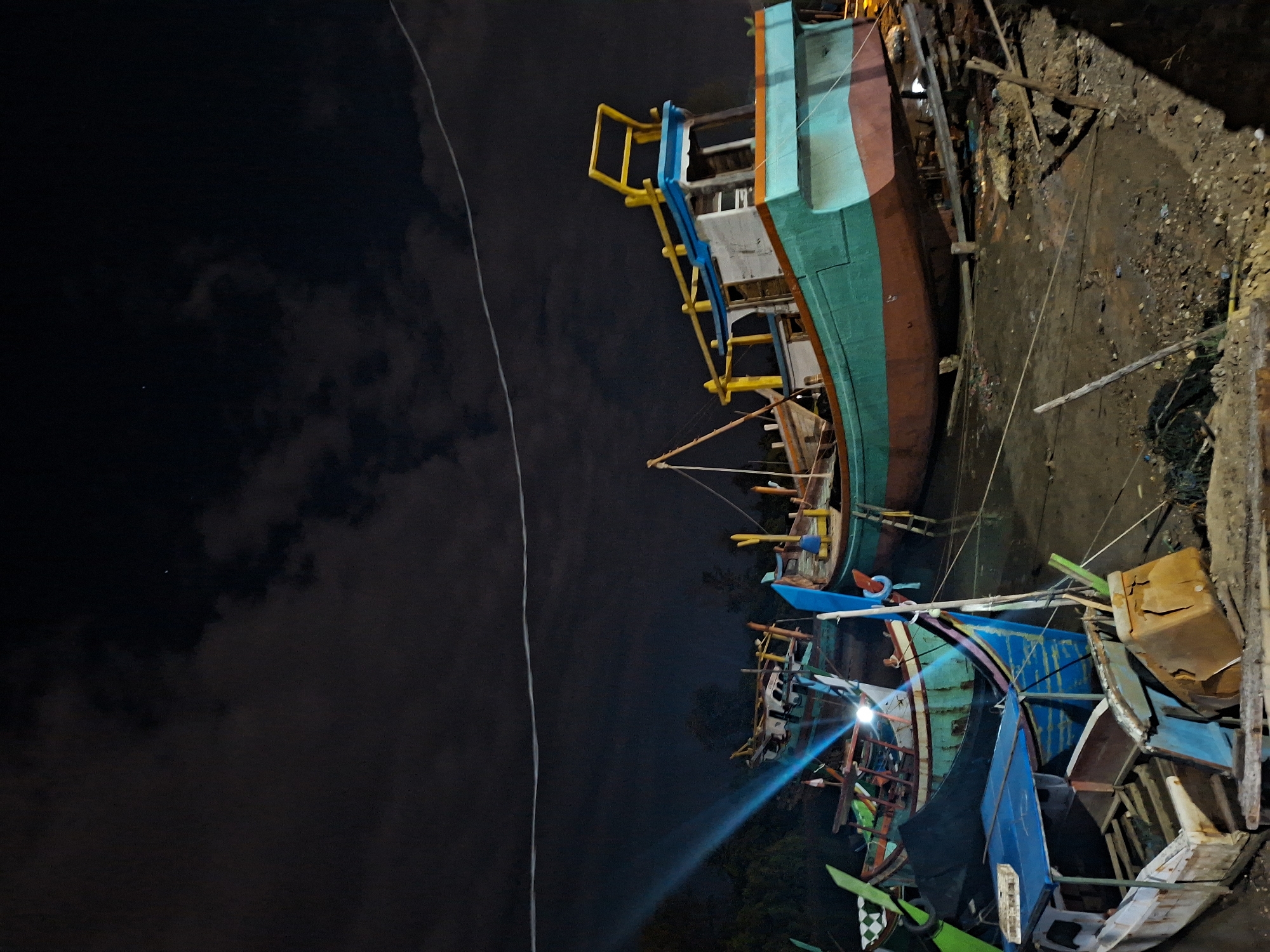 Colorful fishing boats clustered at Lhokseumawe boatyard captured at night