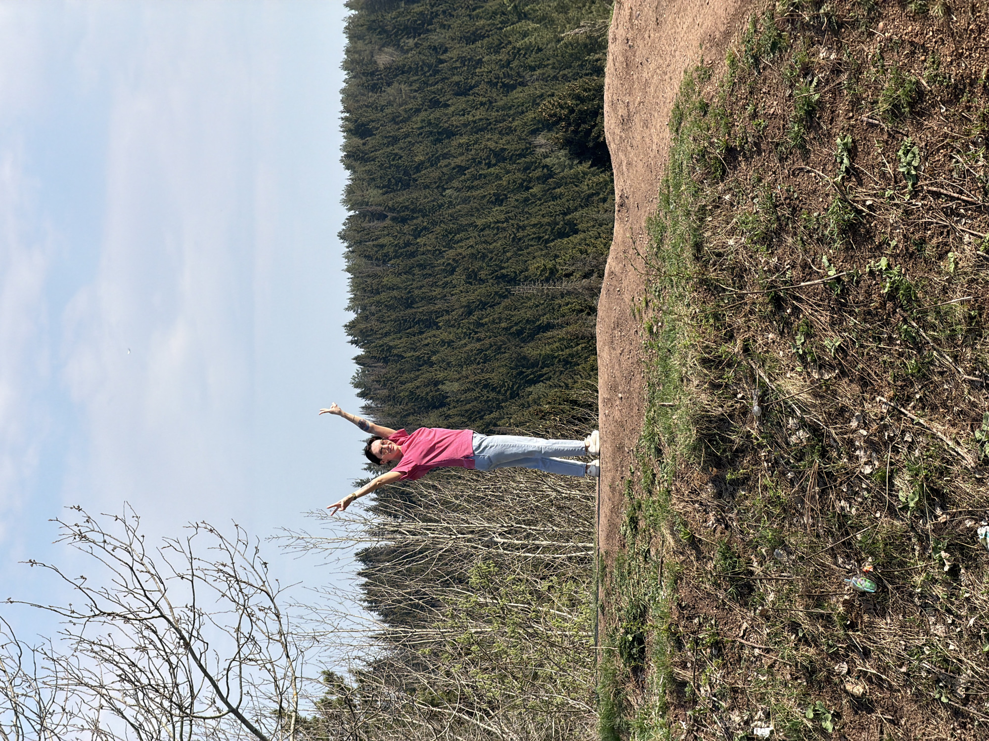 Person celebrates outdoors on Perm hillside during sunny spring day