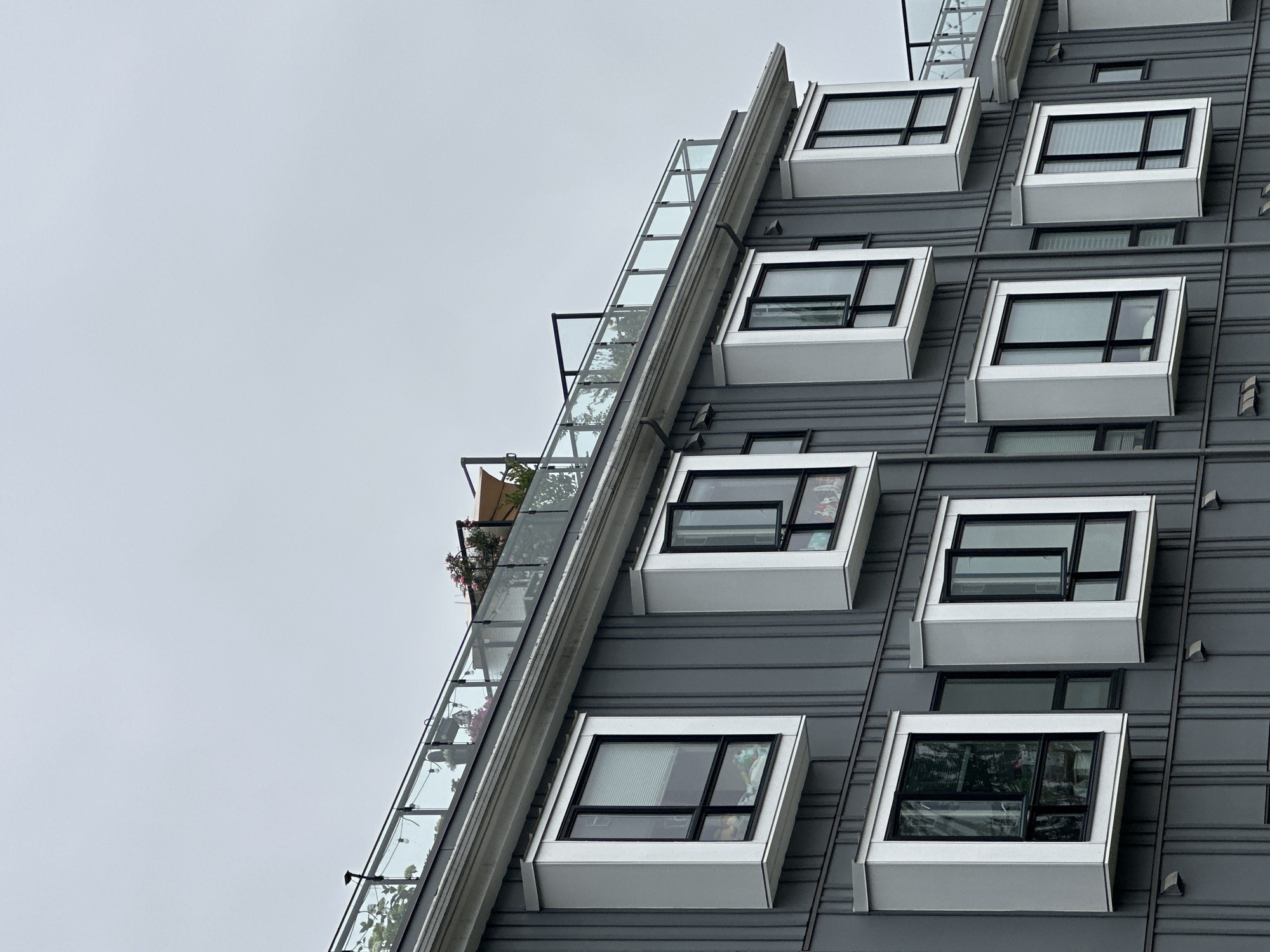 Ribbed gray apartment building with white window boxes in Burnaby