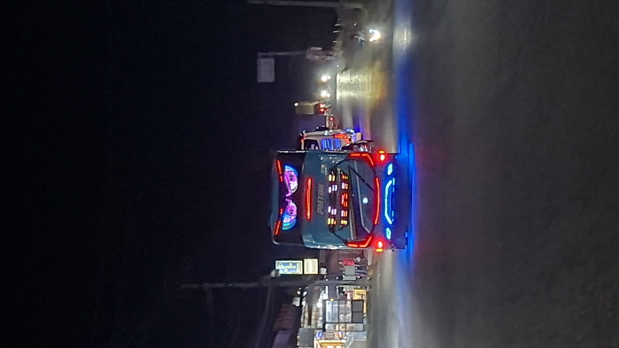 Ornately lit decorative bus driving through Keudegeudong at night