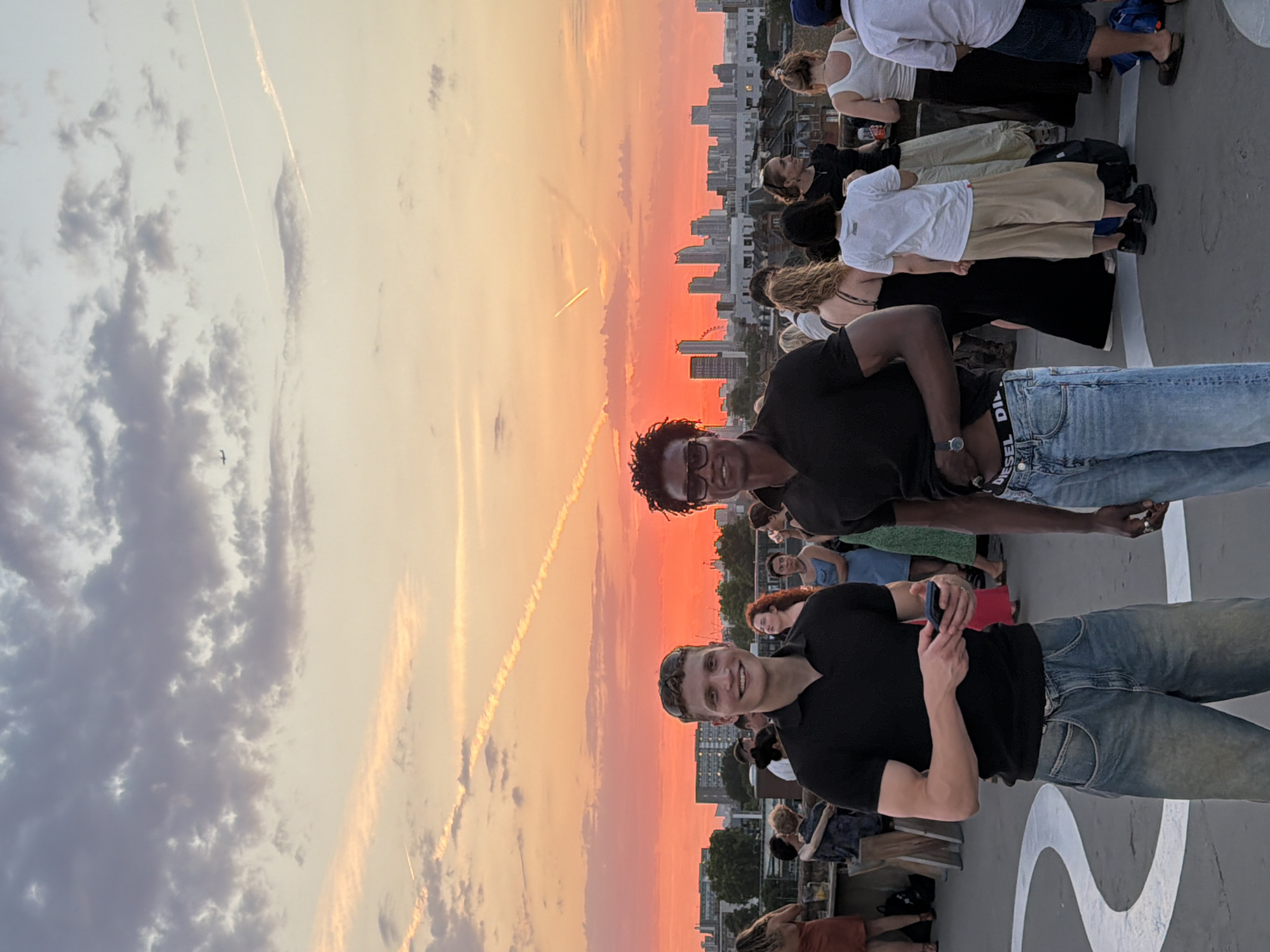 London rooftop crowd watches a vivid summer sunset unfold