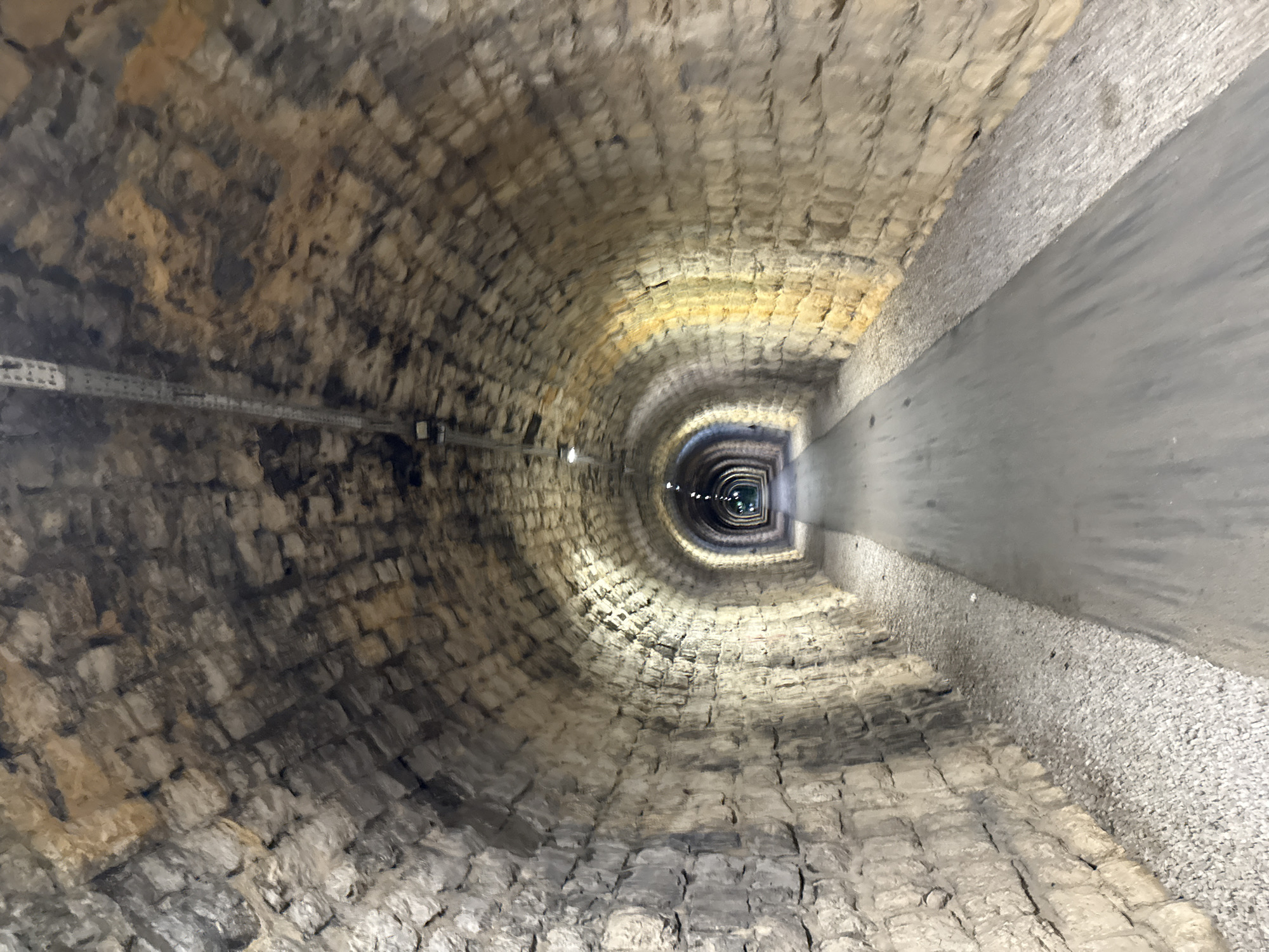 Stone-arched tunnel with ceiling lights in Sasovići, Montenegro