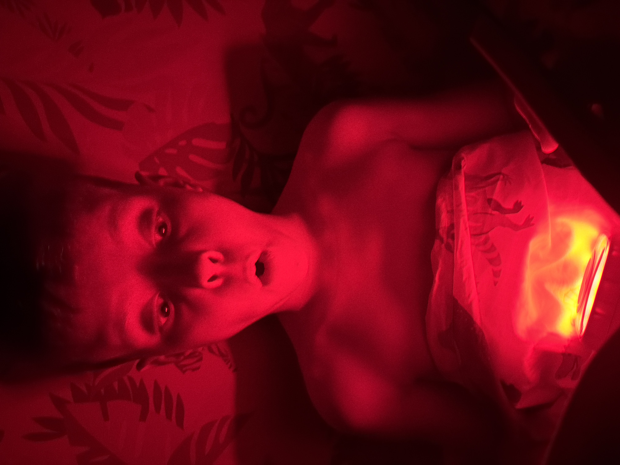 Child plays with colored light device in Votkinsk bedroom