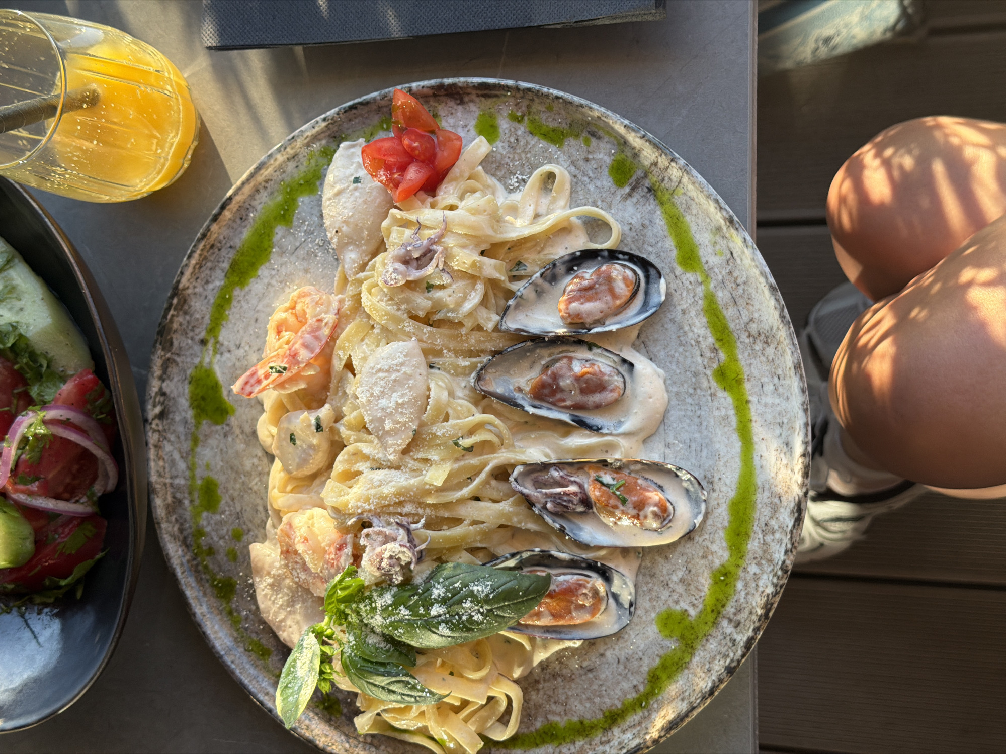 Woman enjoys seafood pasta at Montenegro coastal restaurant