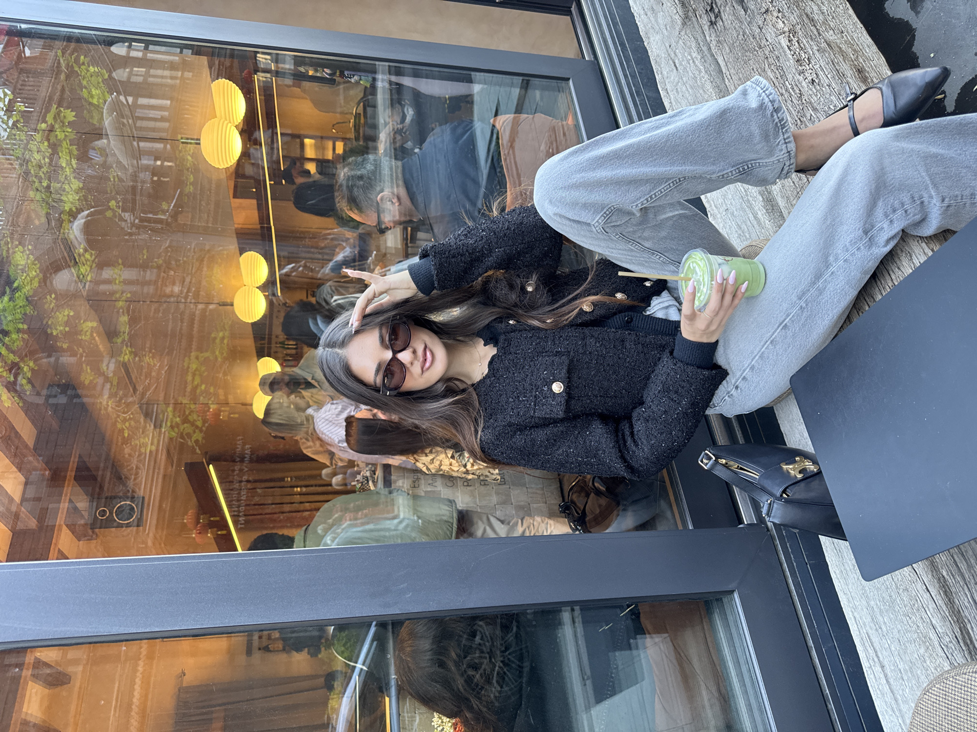 Woman enjoys matcha at Yerevan cafe amid pastry display