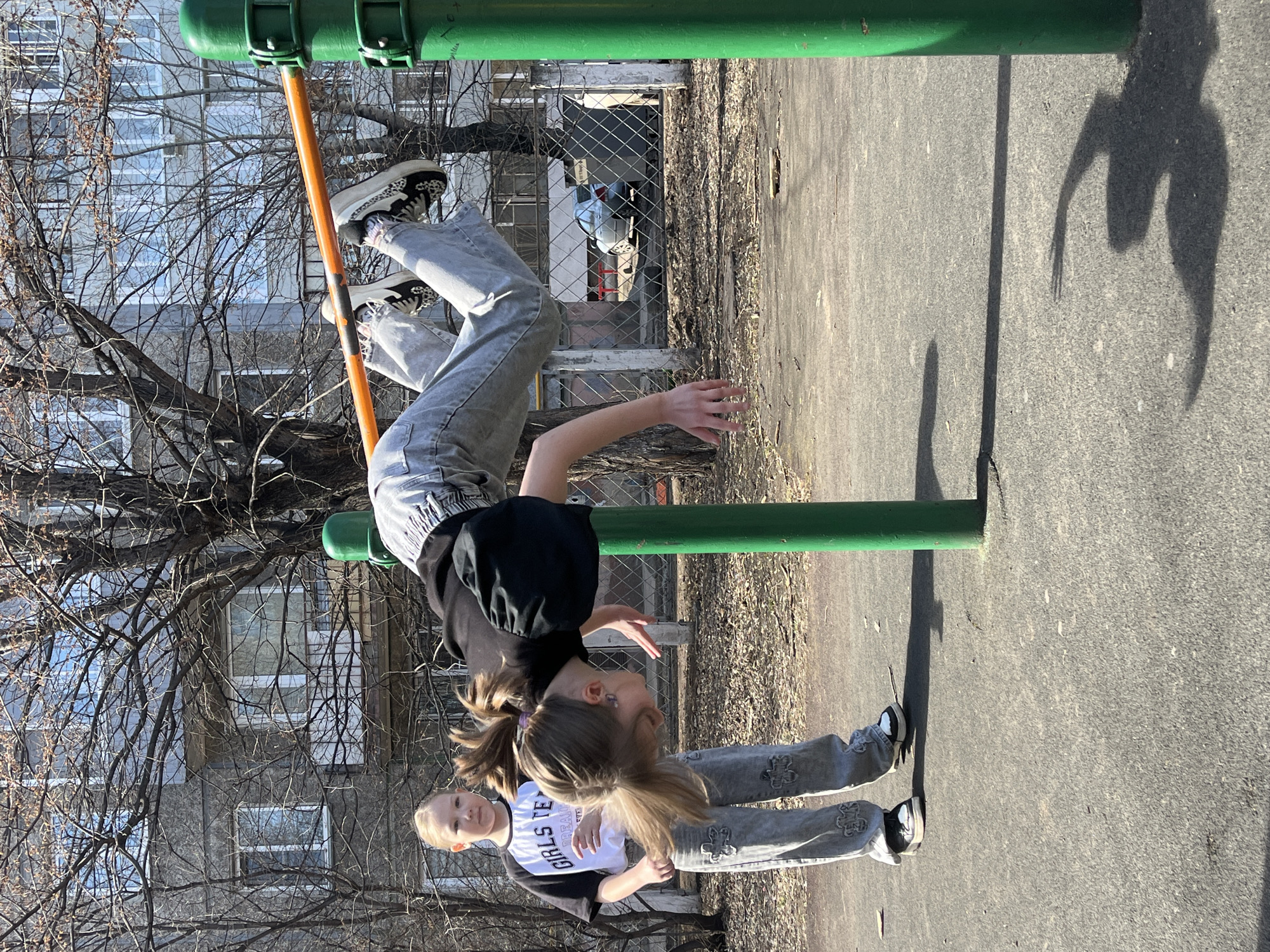 Girls play at sunny Krasnoyarsk playground during spring morning