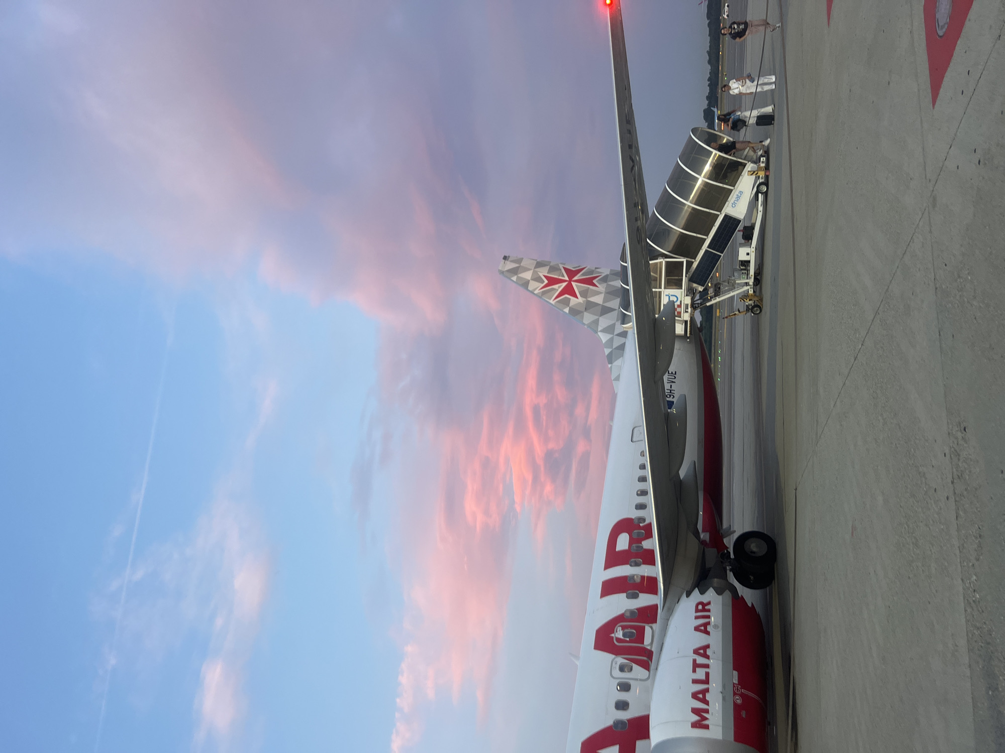 Malta Air 737 unloads passengers at Malpensa under a sunset sky