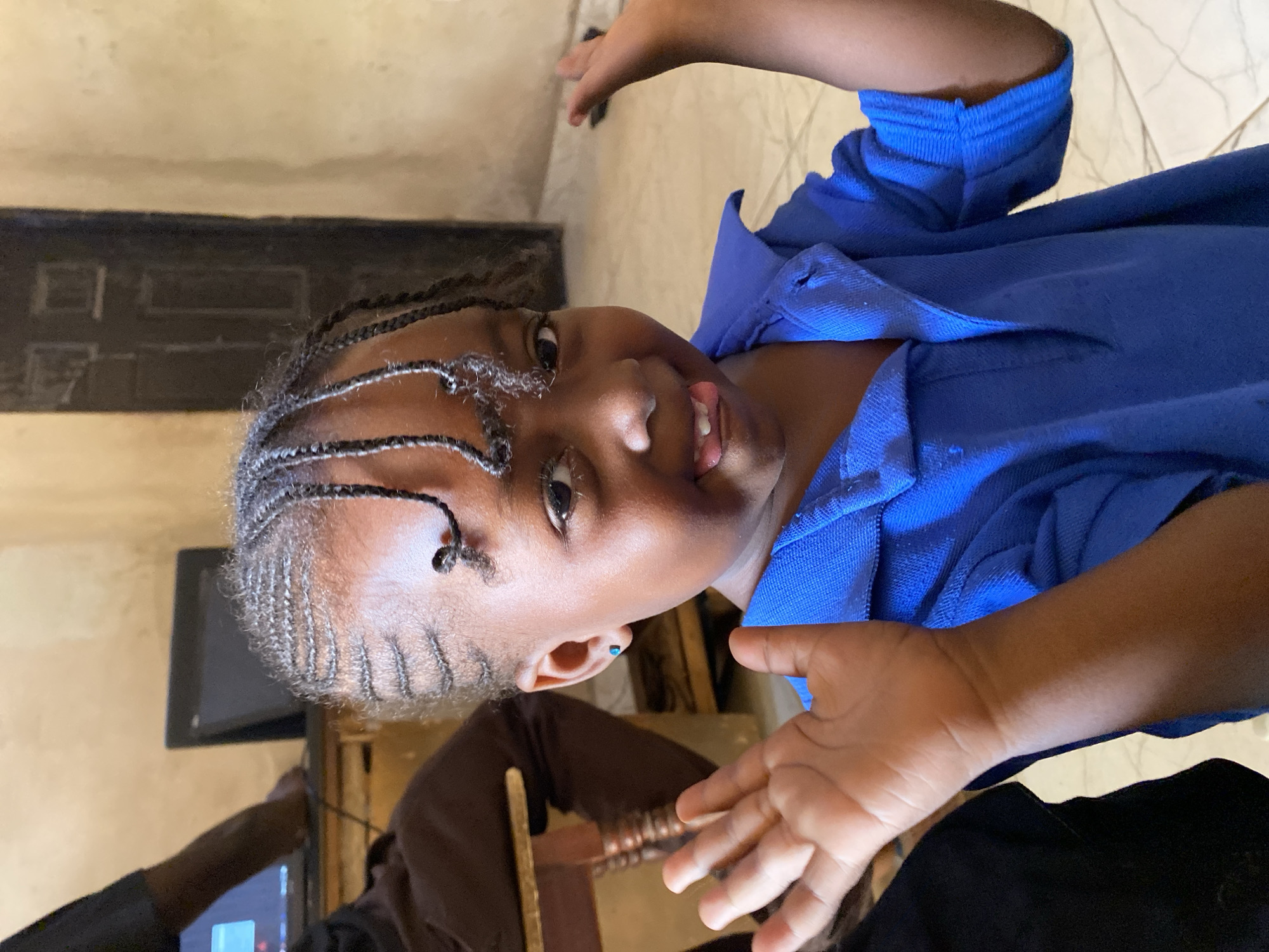 Young girl dances joyfully indoors in Kuru Dungus, Nigeria