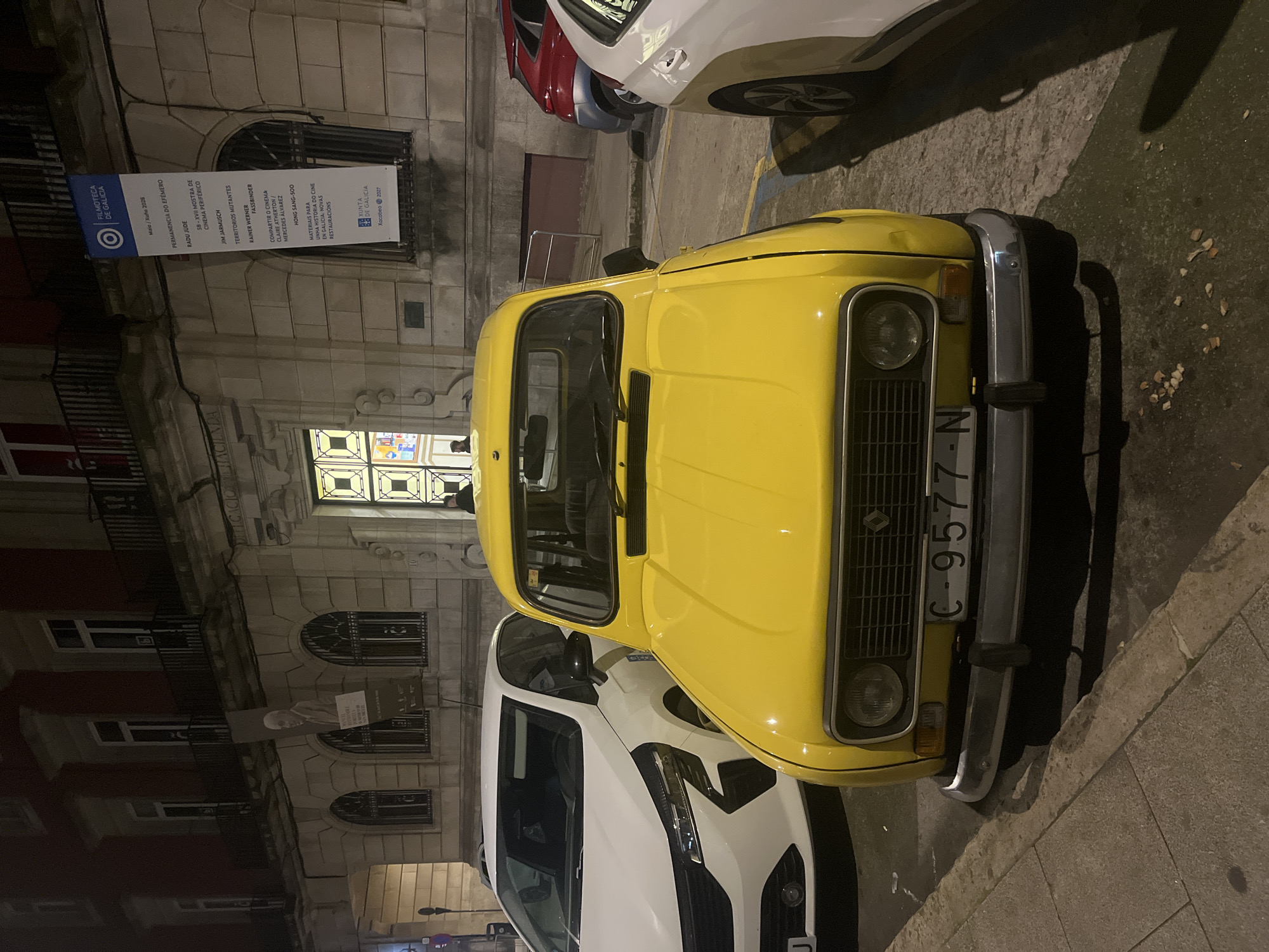 Yellow Renault 4 spotted near illuminated historical building in A Coruña