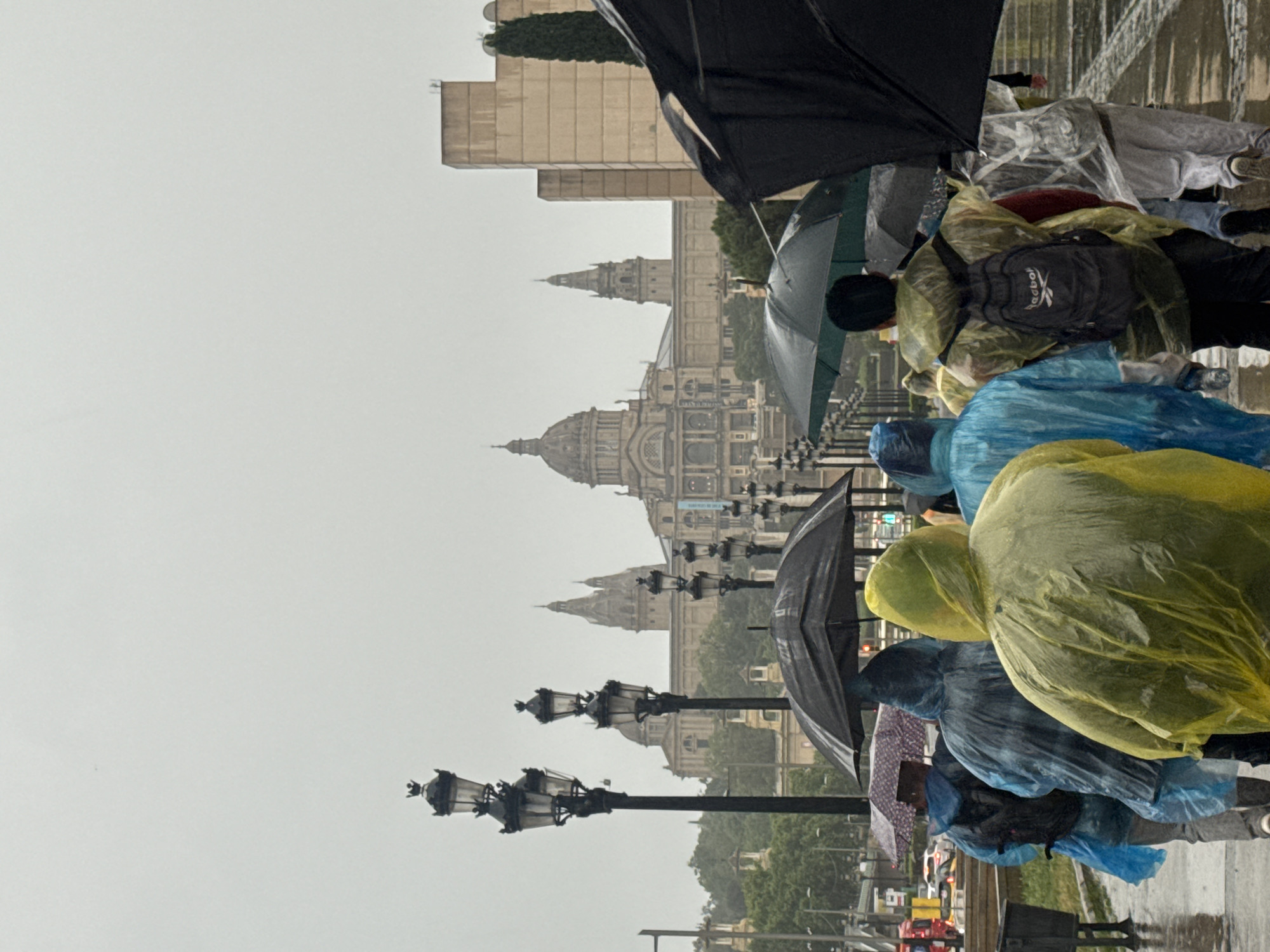 Rain soaks Barcelona's Plaça d'Espanya as visitors brave weather