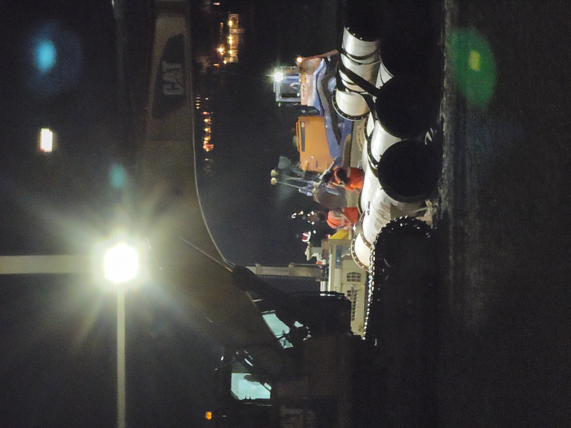 Night infrastructure work in Quarteira with excavators and large pipes