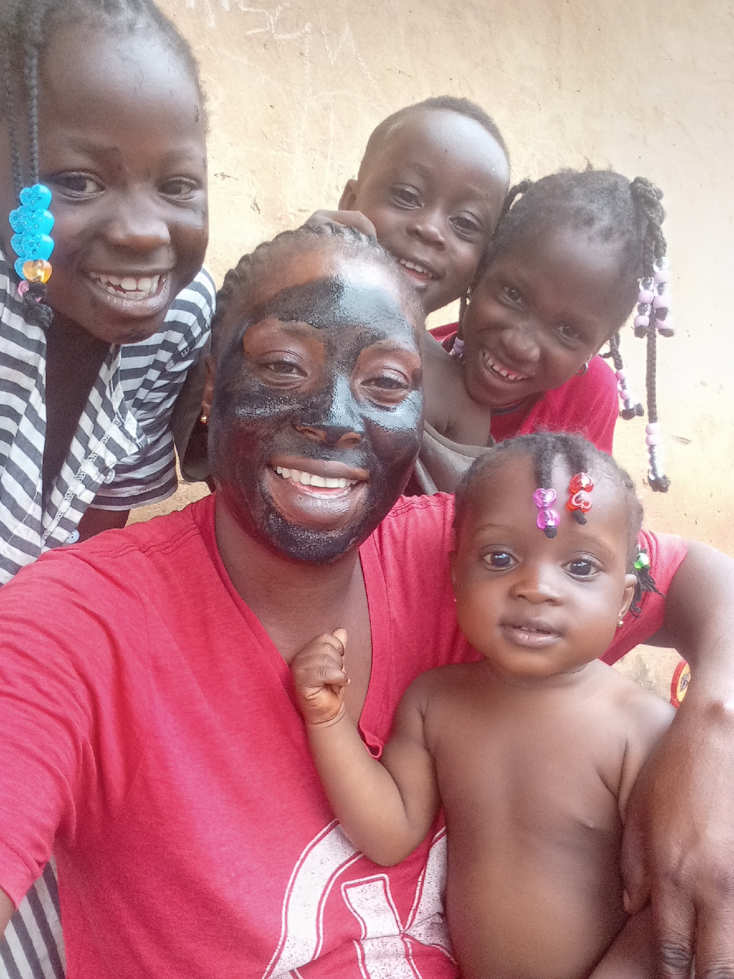Woman and children apply facial masks in Akwanga, Nigeria