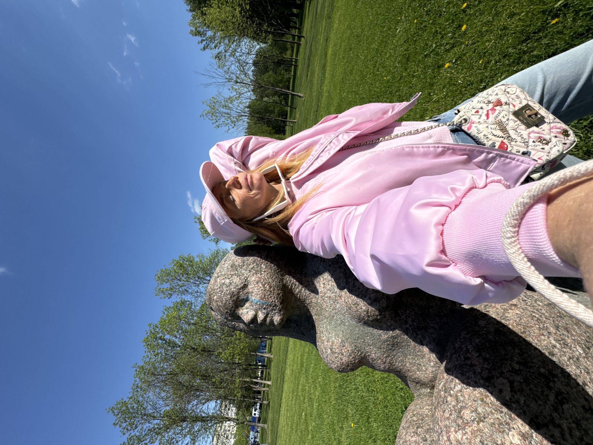 Tourist poses with nude sculptures in Saint Petersburg park