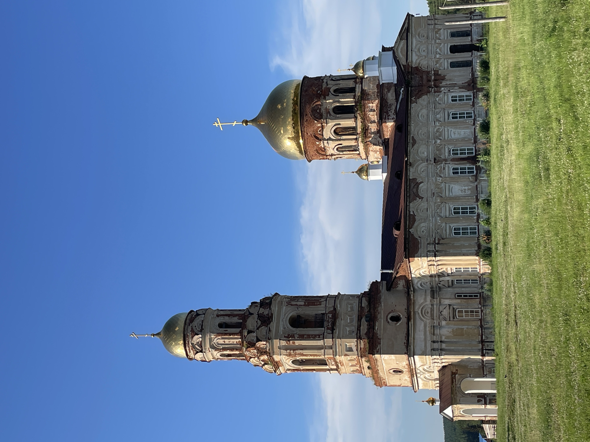 Weathered Orthodox church with golden domes in rural Russia