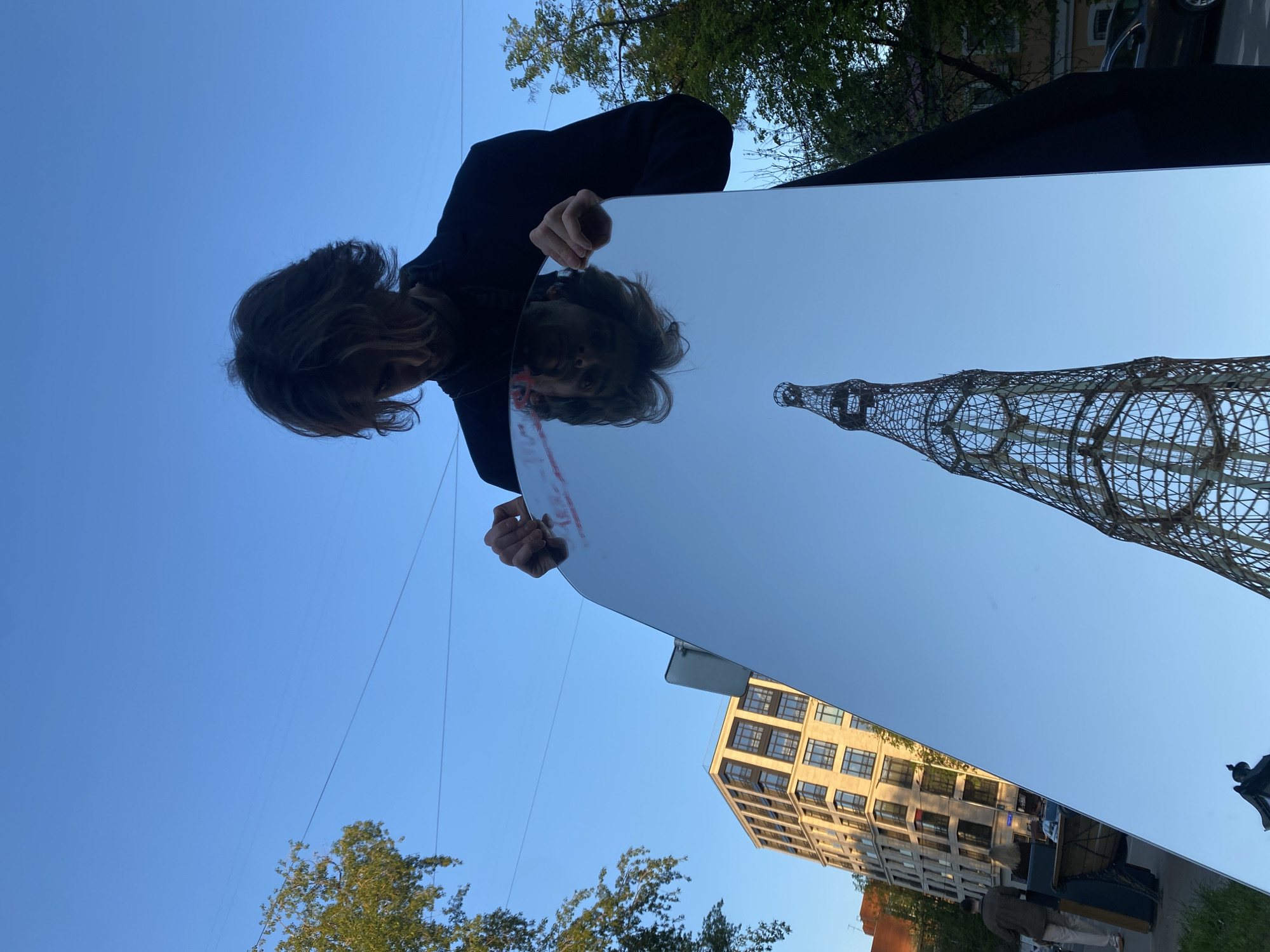 Person captures Shukhov Tower reflection in mirror in Moscow