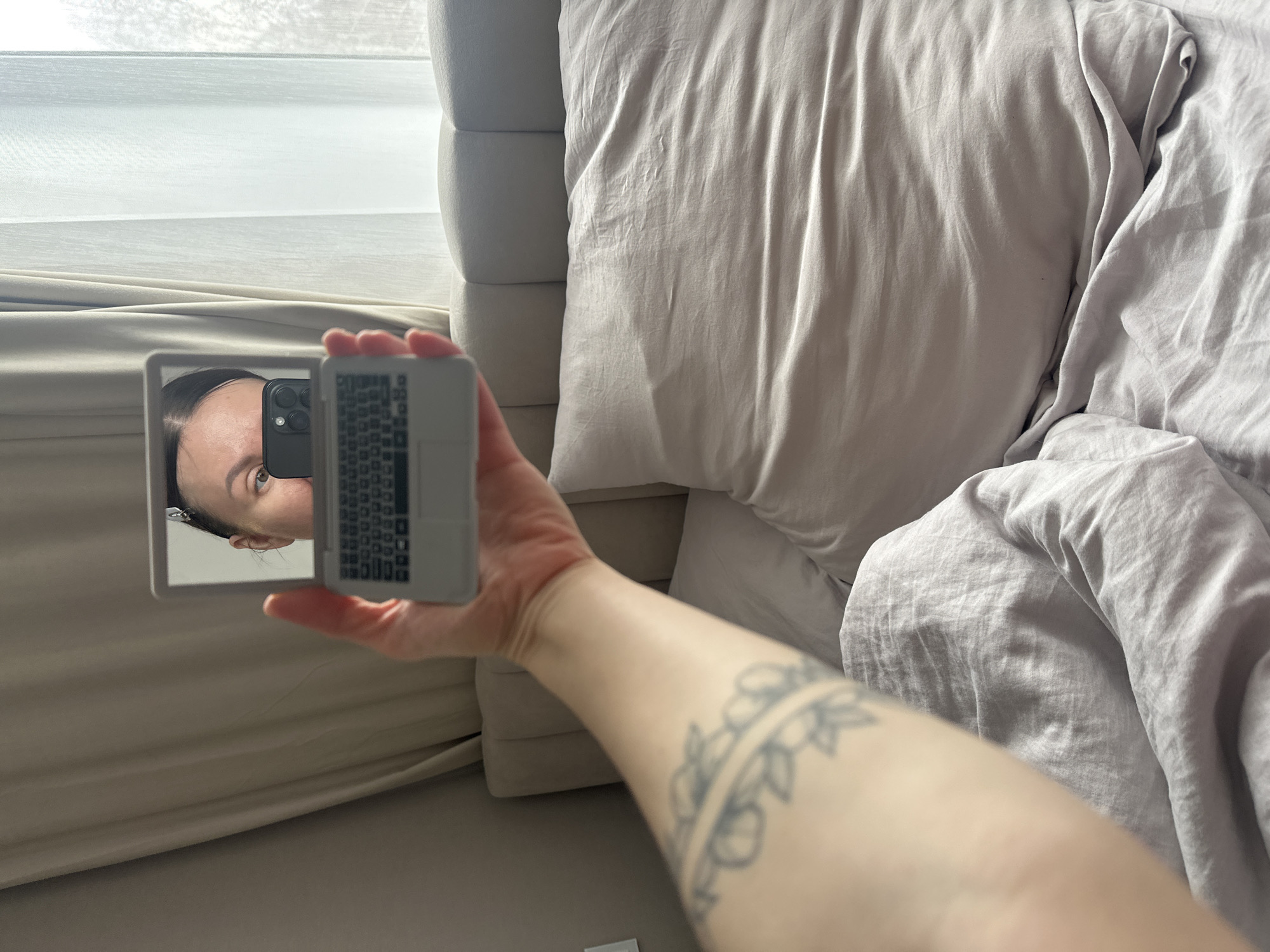 Person examines laptop-shaped compact mirror in Votkinsk bedroom