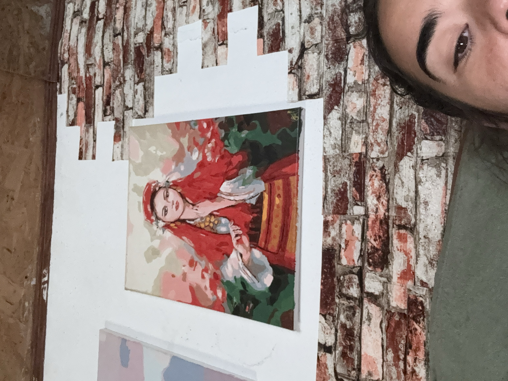 Person photographed in Bulgarian room with woman portrait painting