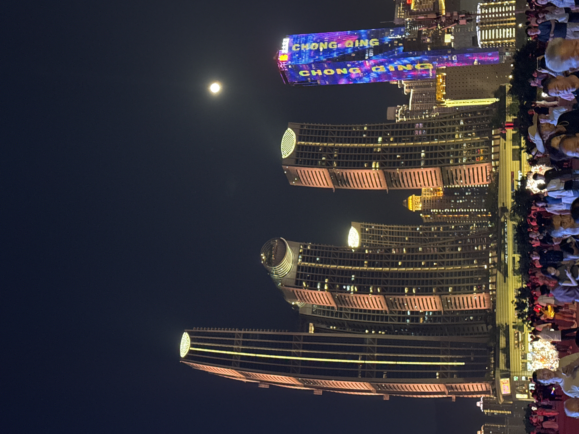 Chongqing's illuminated skyline and evening pedestrian activity captured