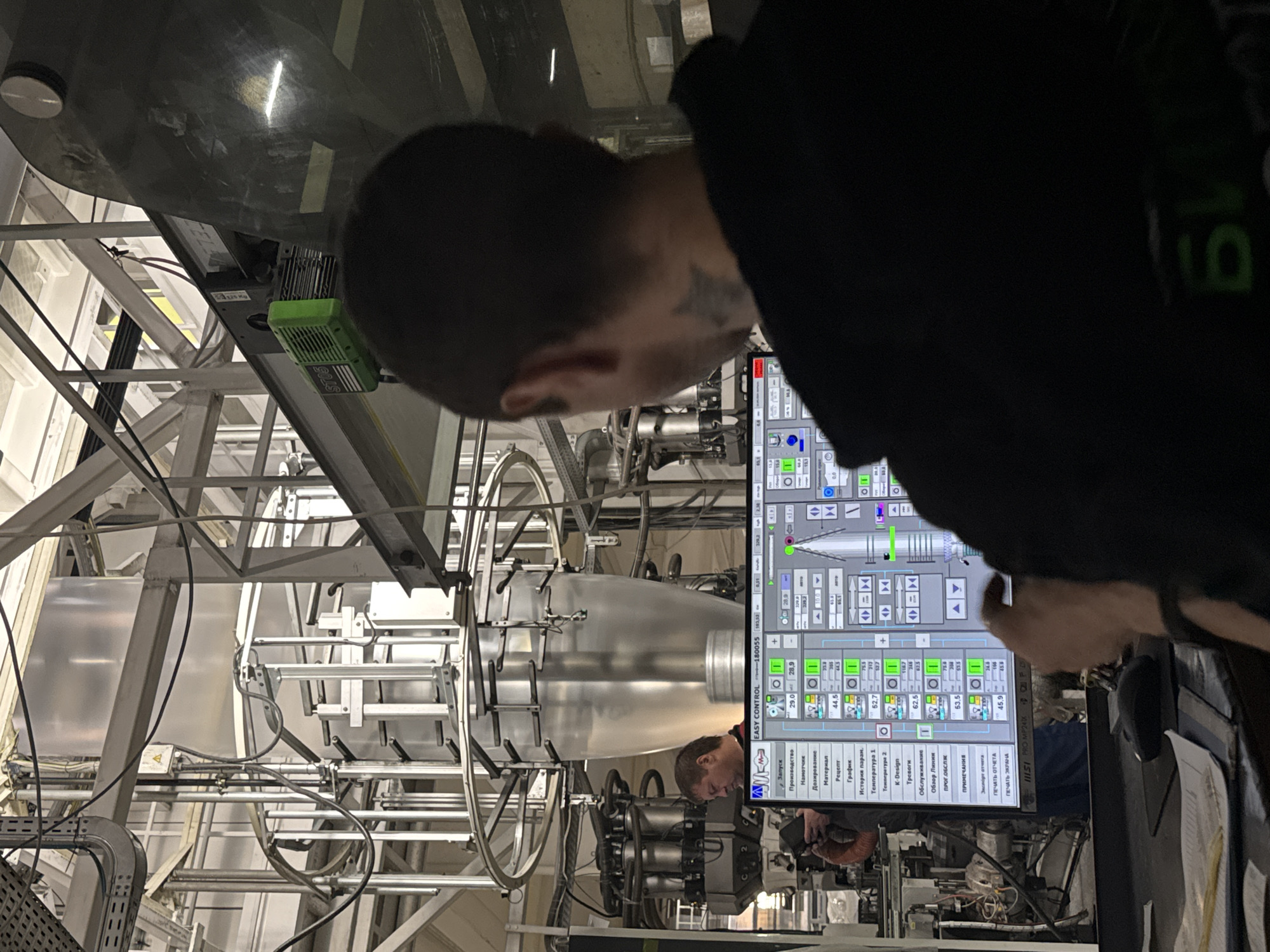 Factory worker operates industrial machinery in Perm manufacturing facility
