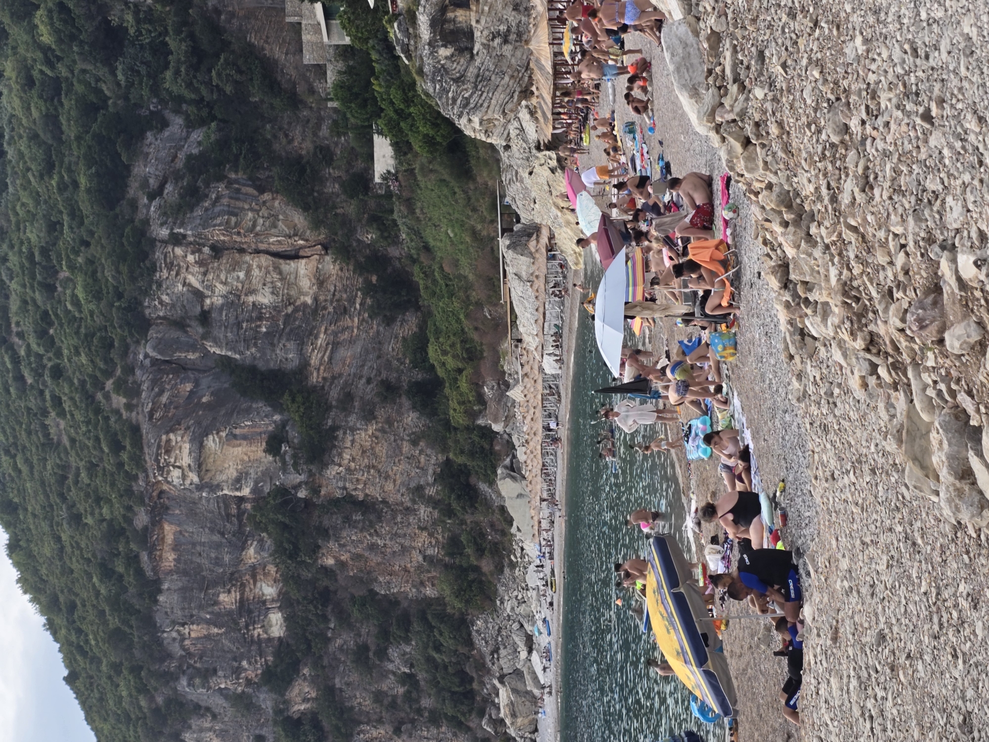 Crowded pebble beach day on Montenegro's Adriatic coast