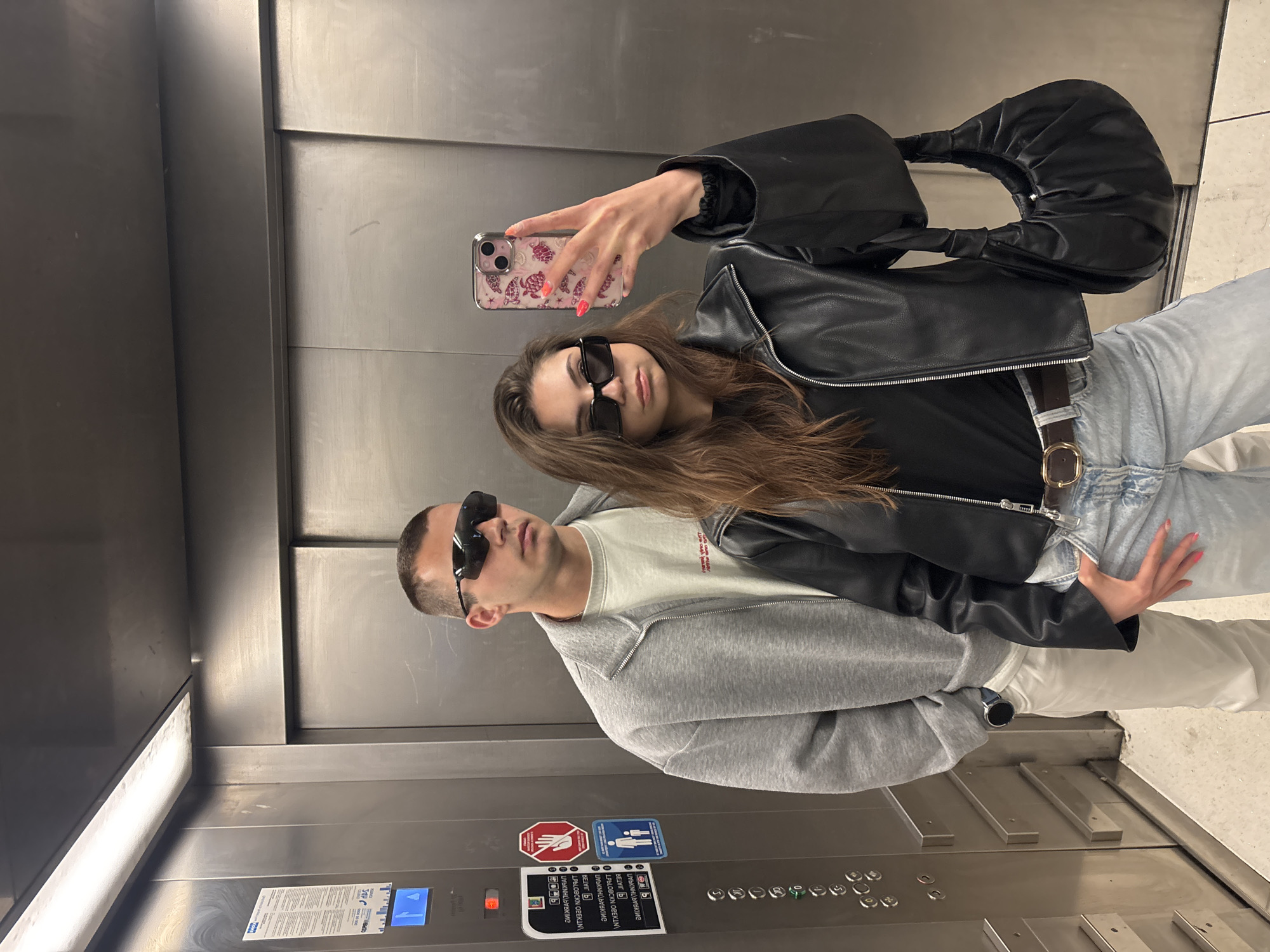 Couple takes sideways selfie in elevator