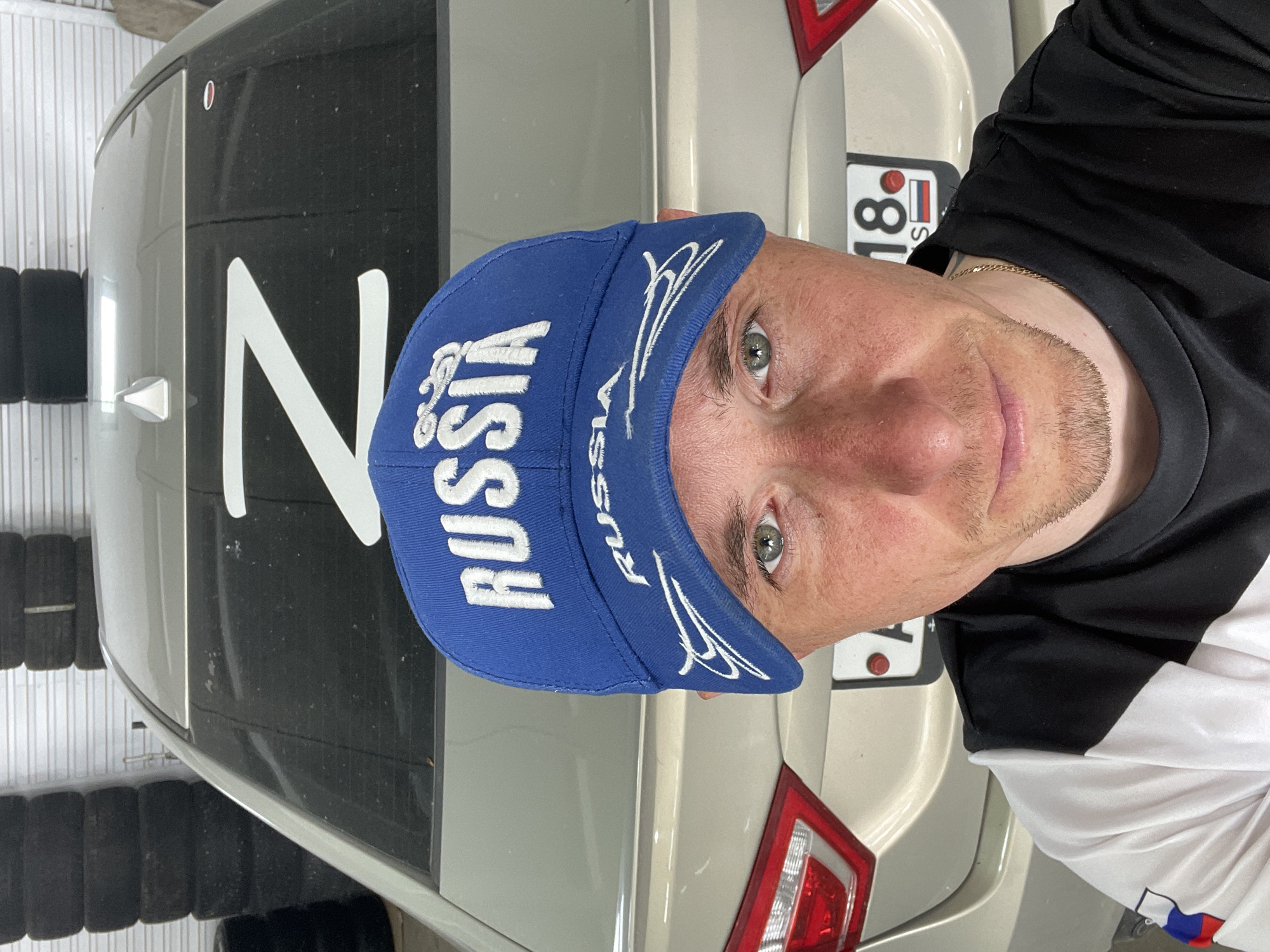 Man in Russia cap takes selfie with vehicle in Sarapul