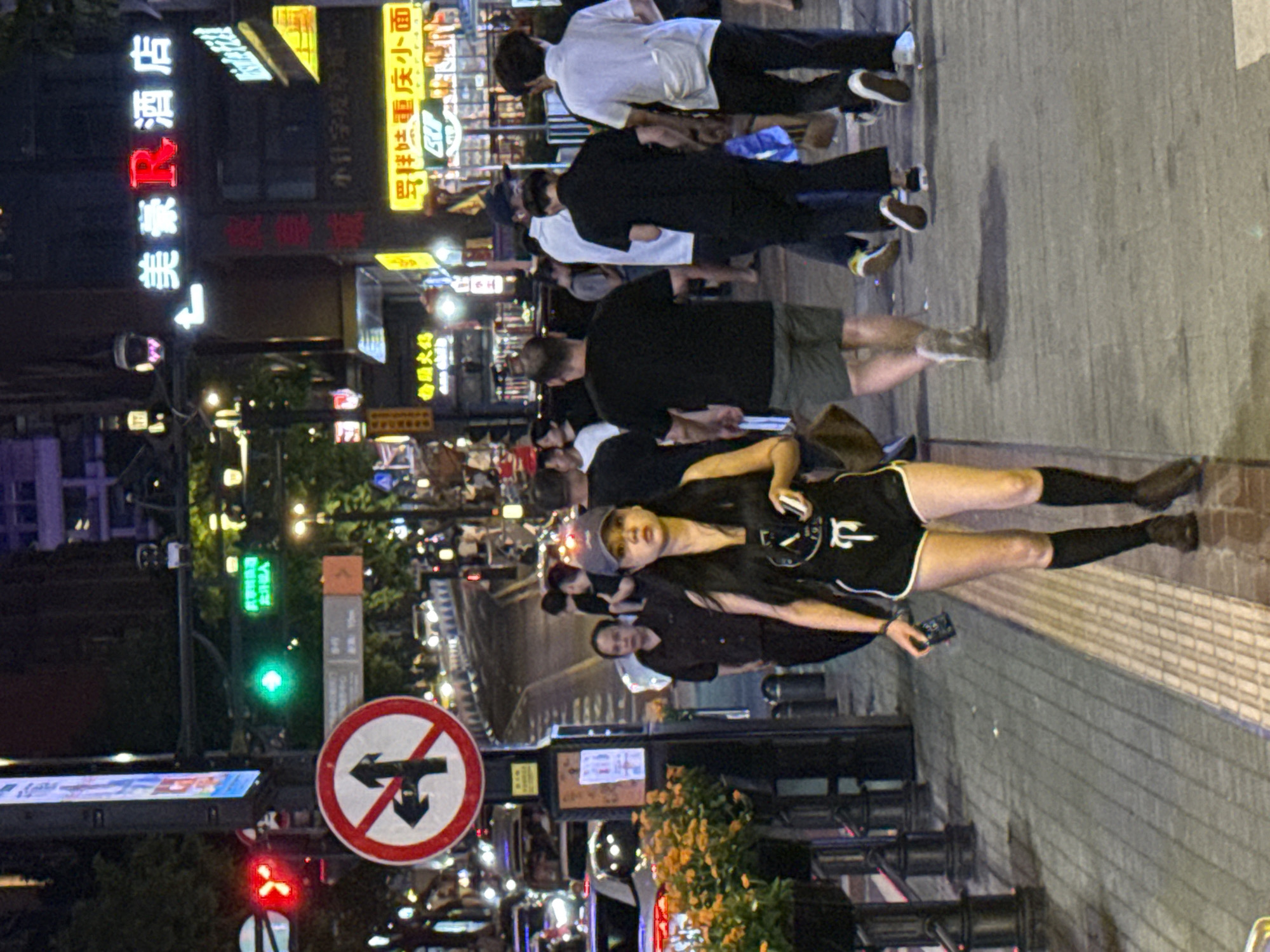 Busy evening foot traffic along Yuzhong District's lit streets