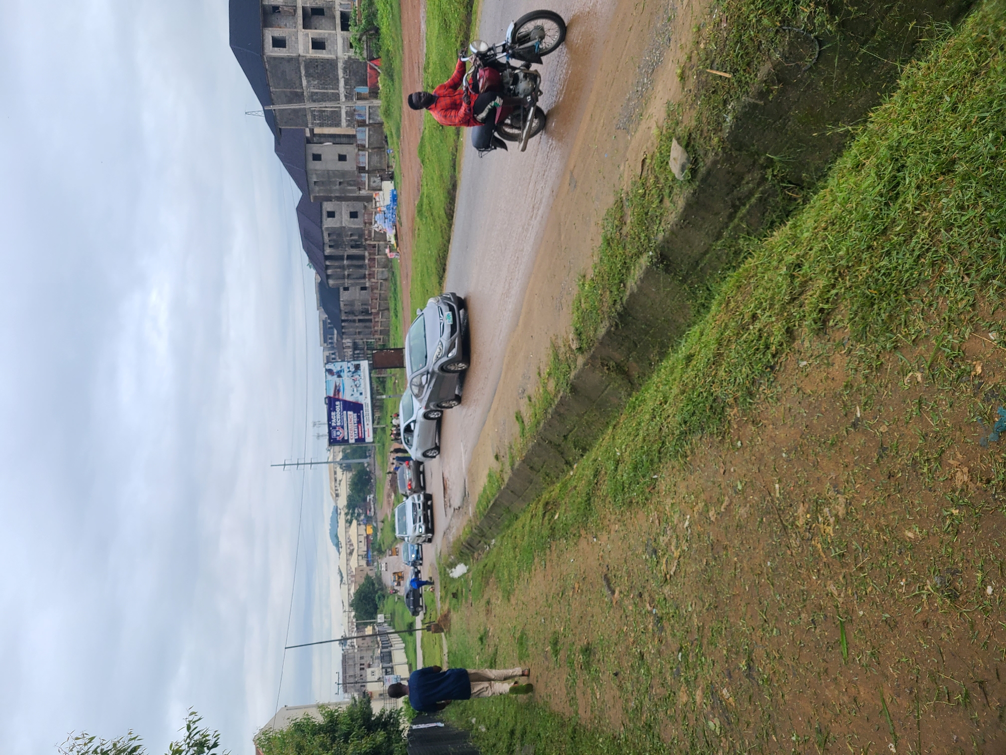 Wet streets and dirt paths on a grey morning in Abuja