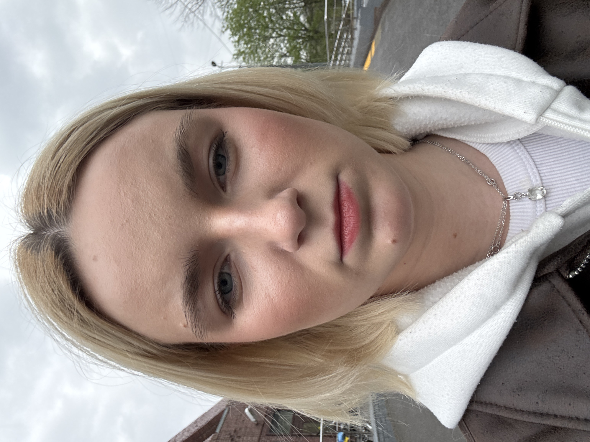 Woman takes selfies on cloudy afternoon in Saint Petersburg