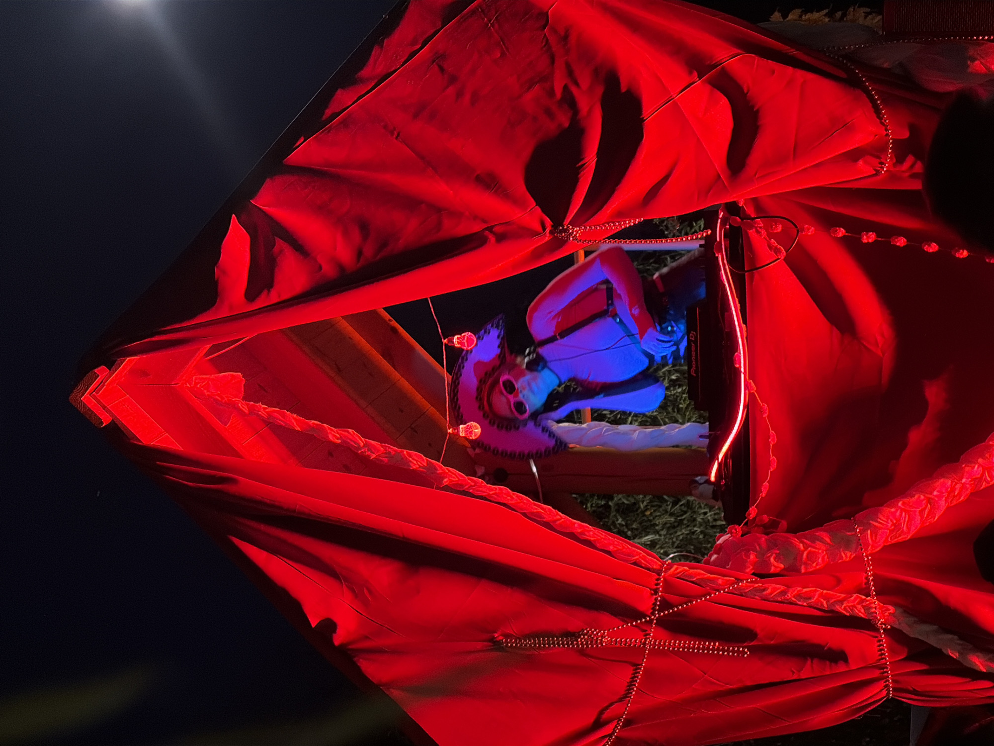 Masked DJ performs under red and blue lights in Moscow