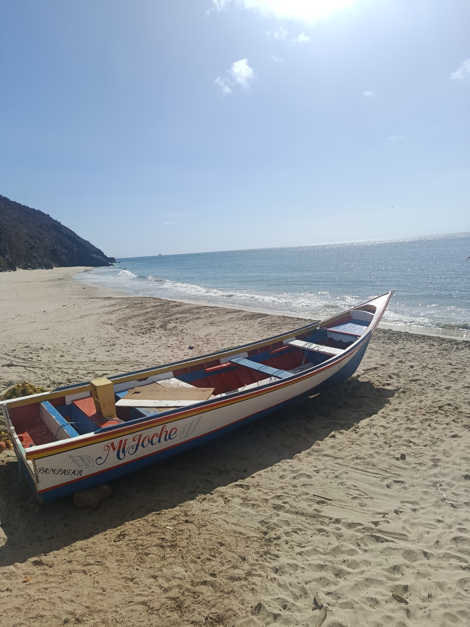 Visitors document colorful fishing boats at Guayacán beach