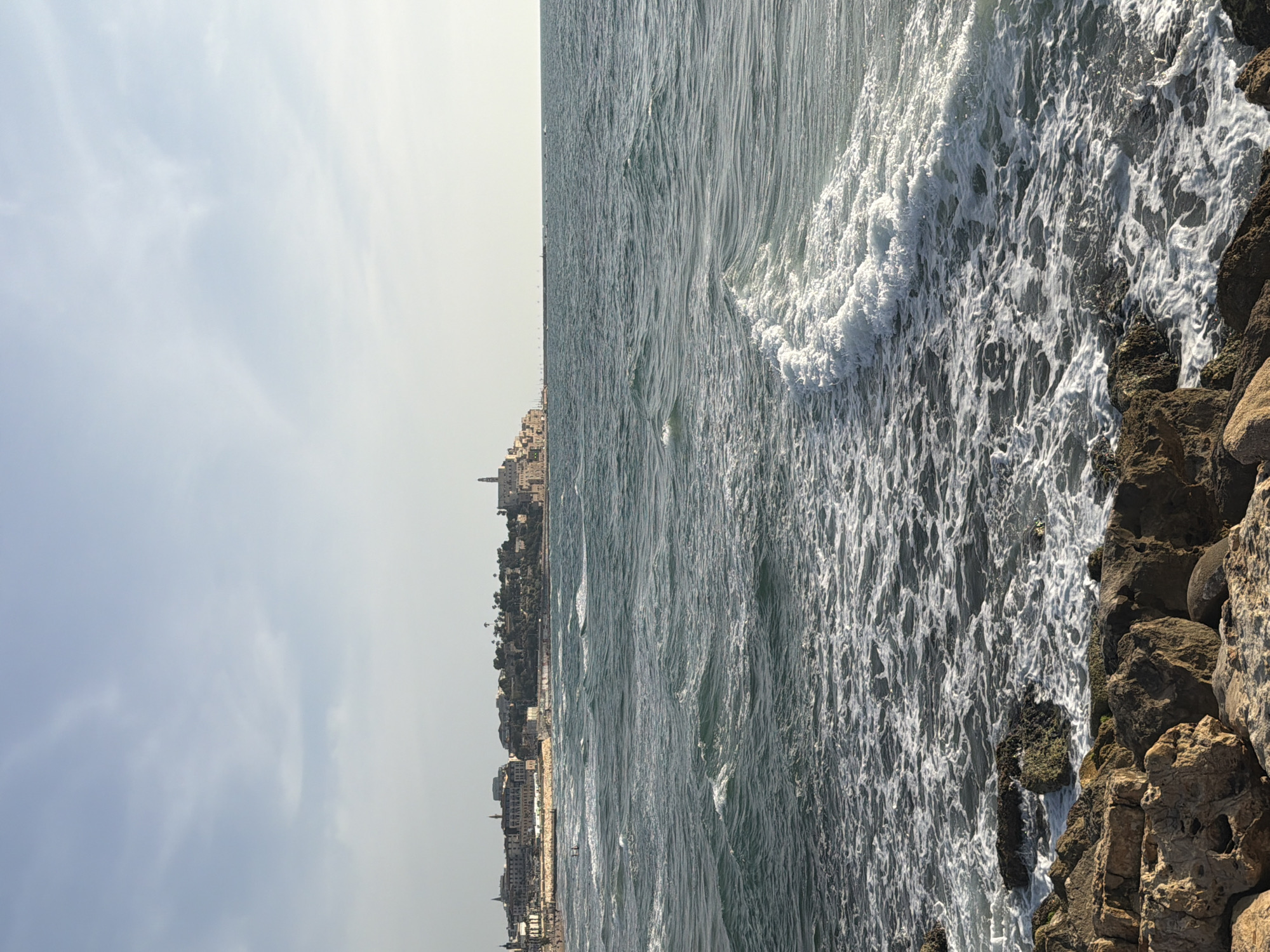 Observer documents Tel Aviv coastal scenes during sunny afternoon
