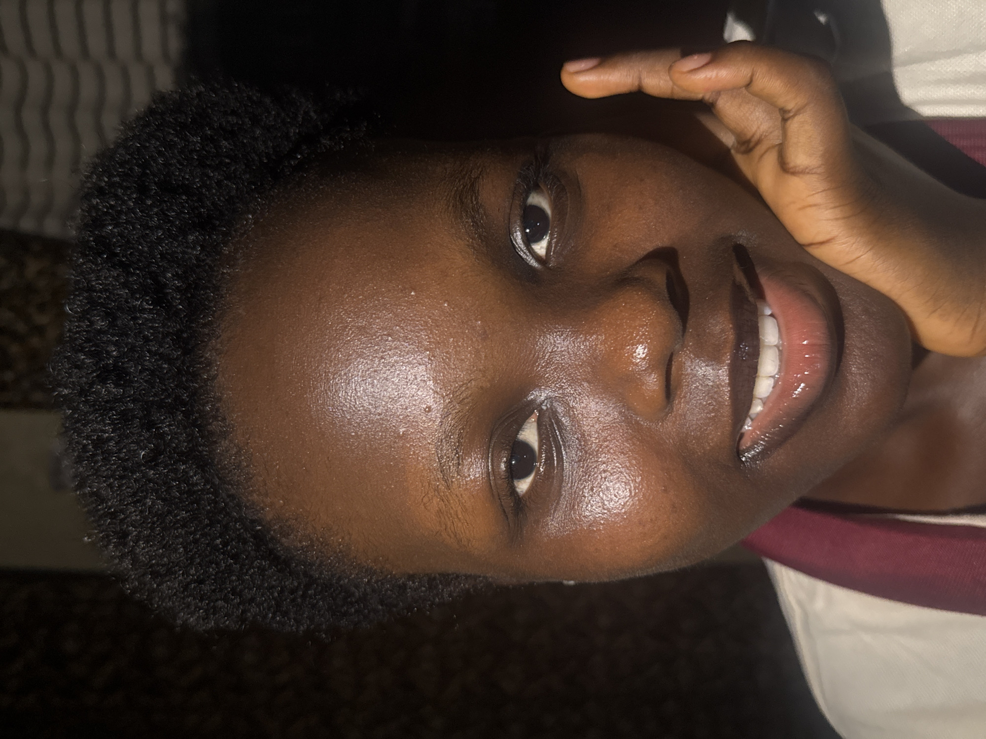 Young woman photographed writing and smiling in Onitsha, Nigeria