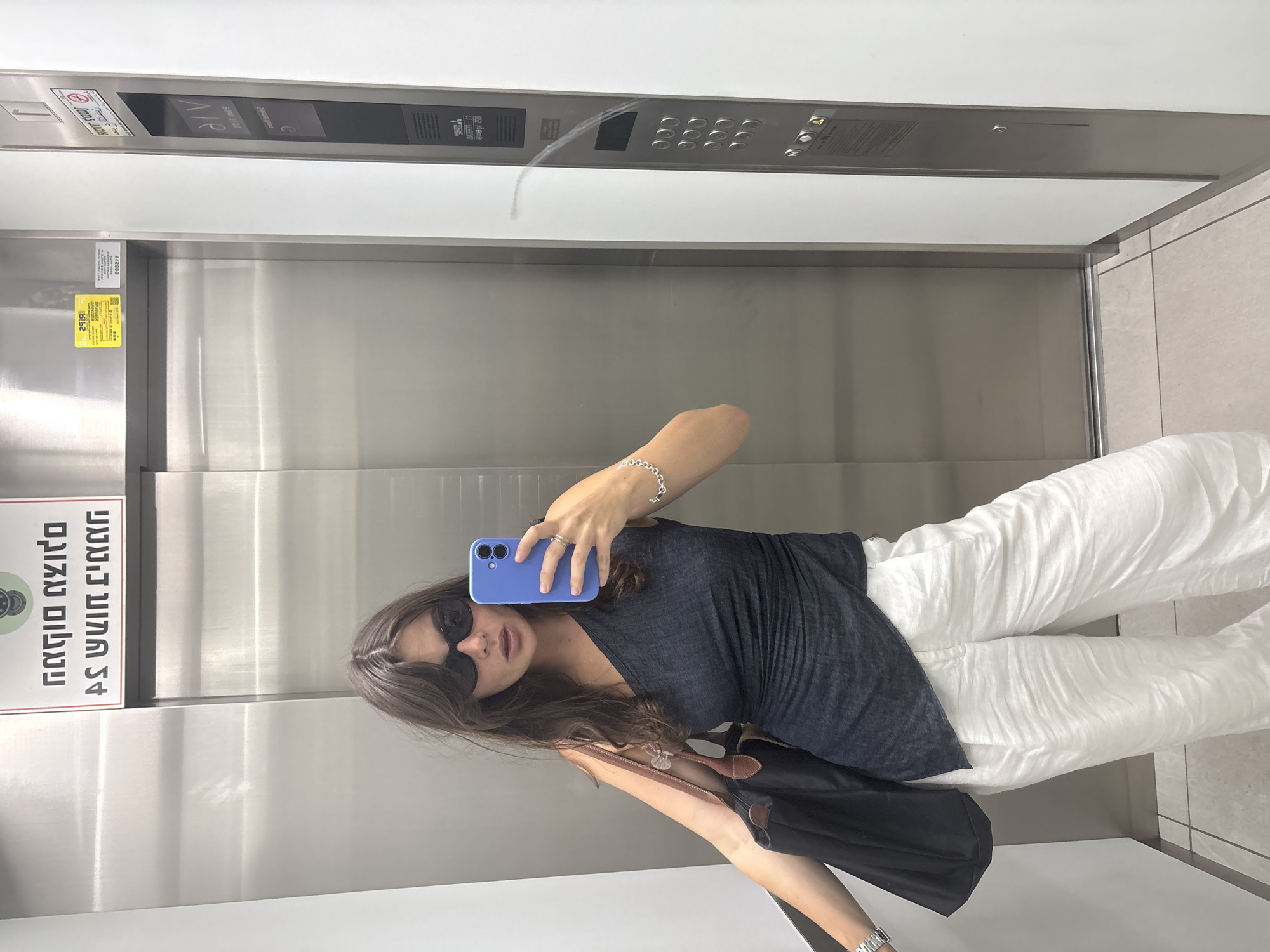 Woman takes selfie in elevator lobby