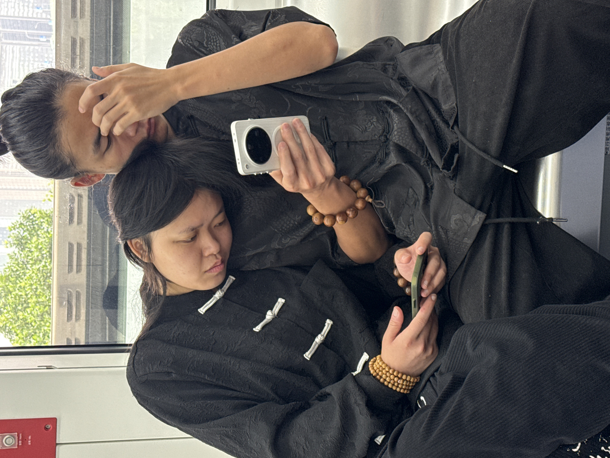Two in traditional dress photographed on Yuzhong subway train