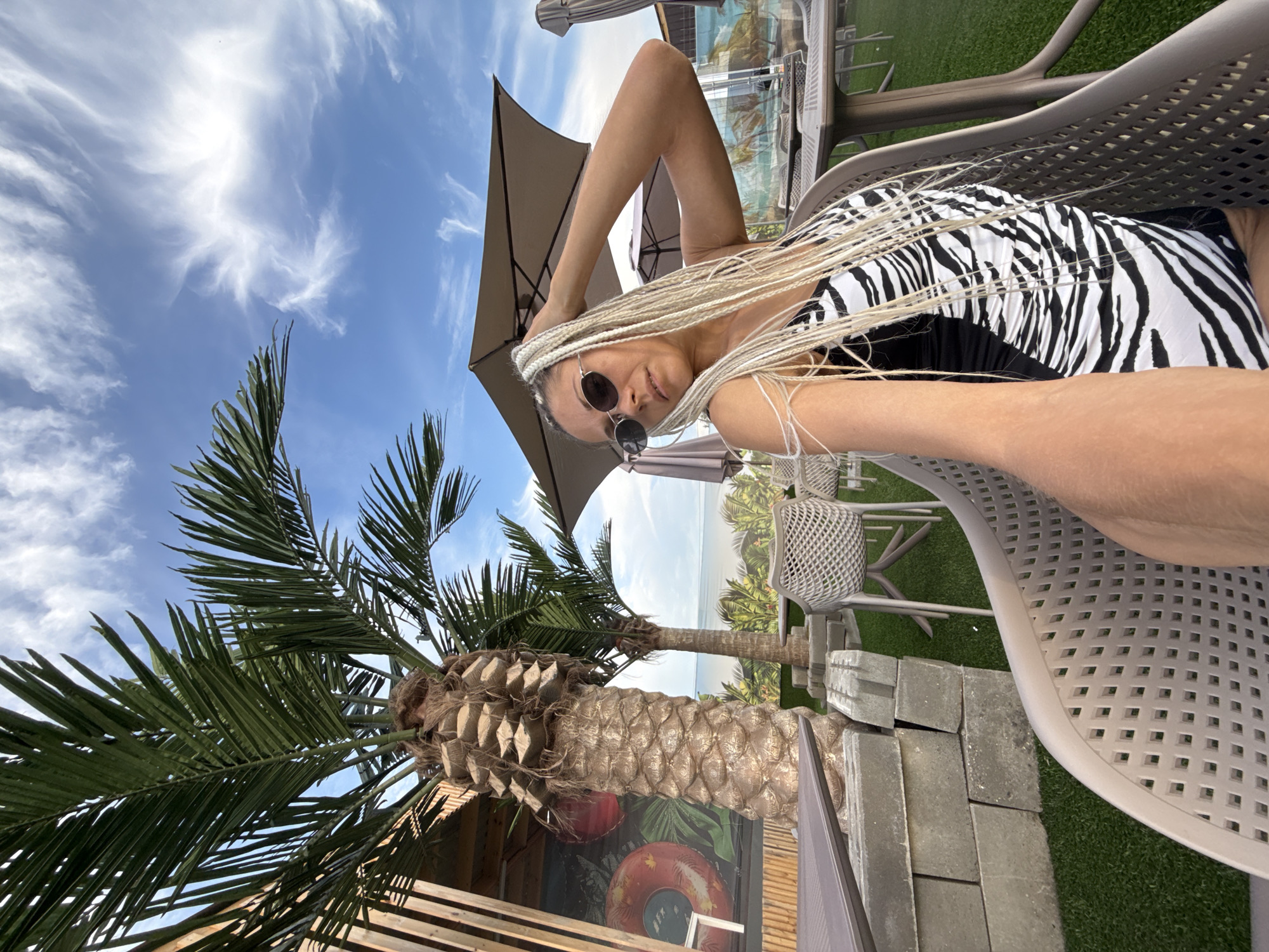 Relaxing outdoors in a zebra-print swimsuit under a shaded umbrella