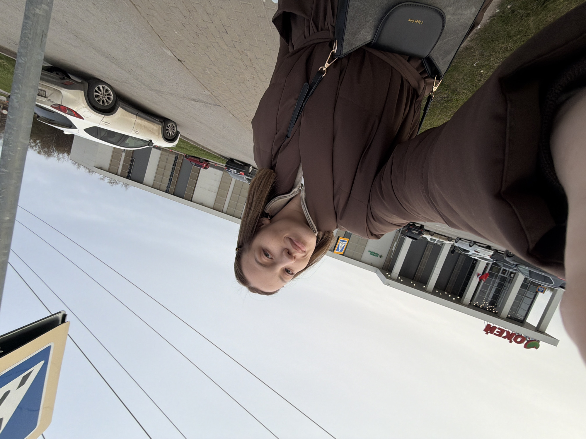Woman takes selfie outside OK'EJ building in Klin, Russia