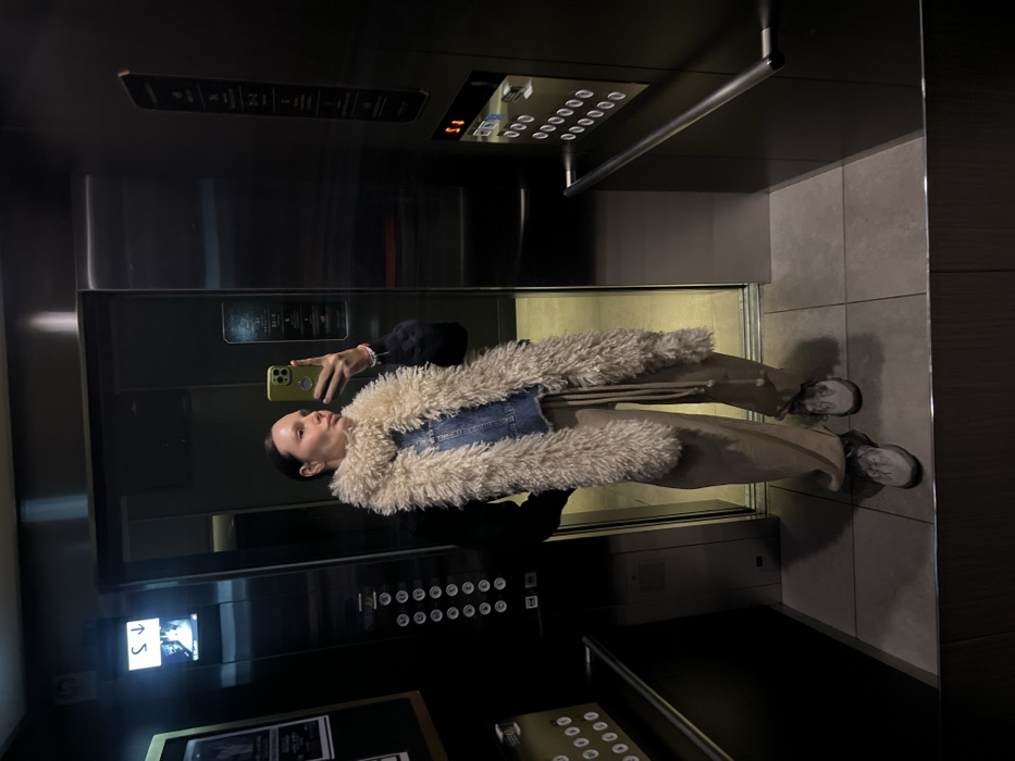 Woman takes elevator selfie with green phone in Osaka