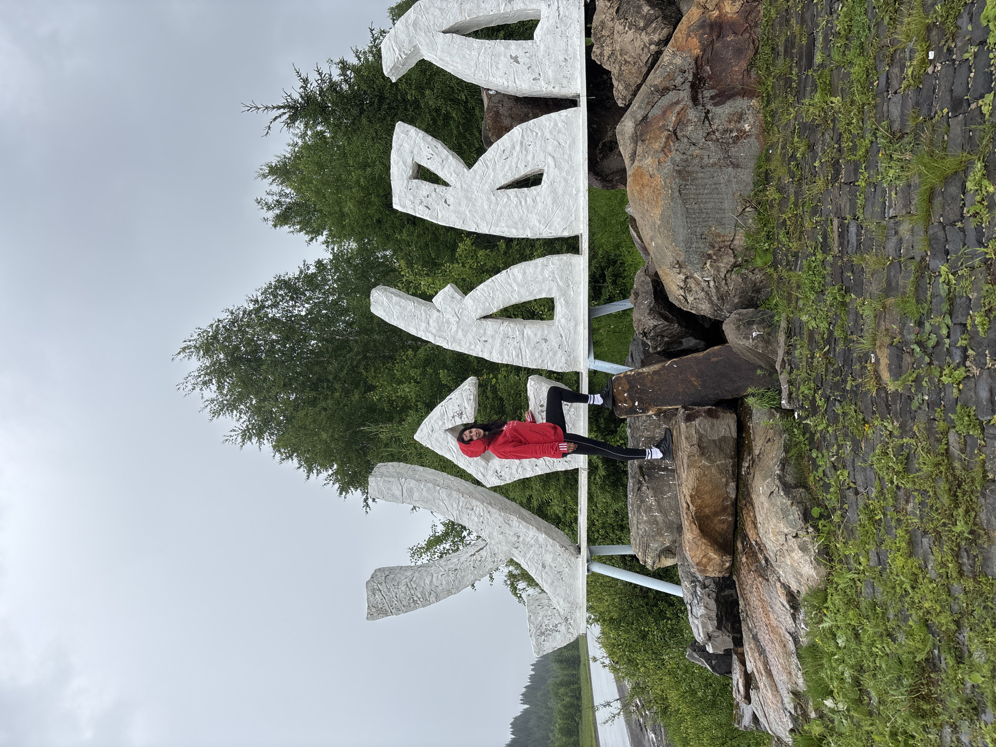 Women pose for photos at Gremyachinsk town sign
