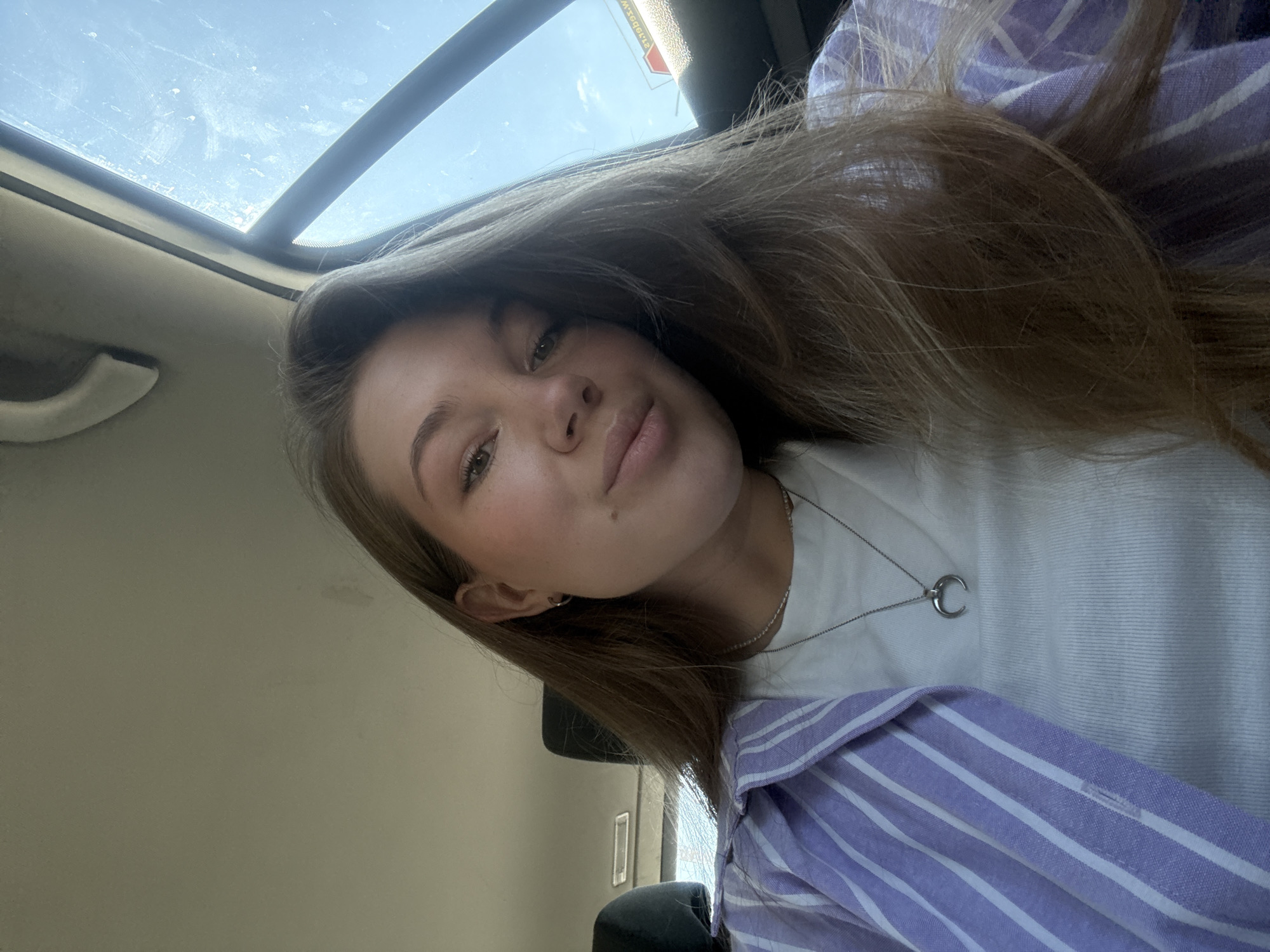Woman takes selfies in car in Belgrade morning